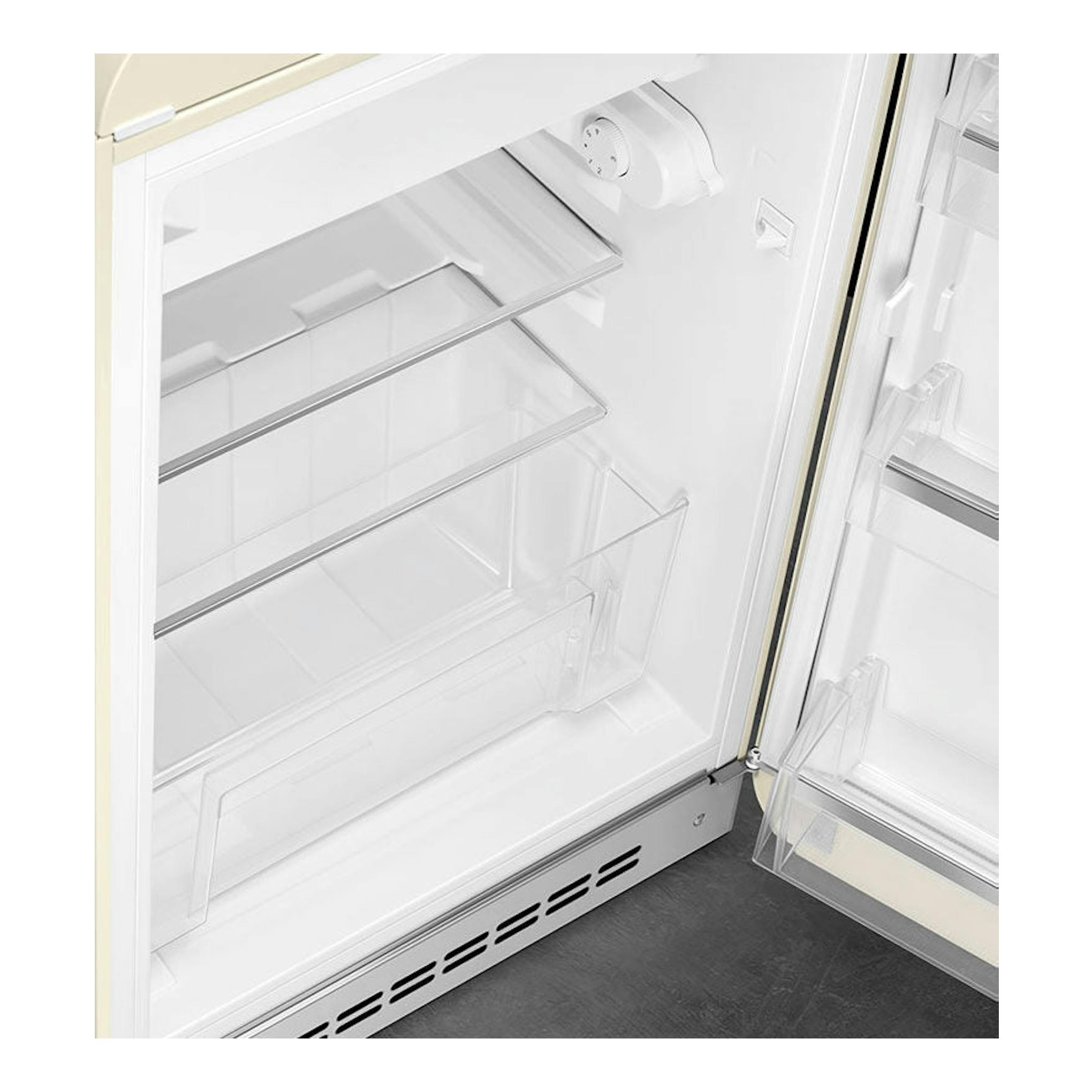 Vista frontal del interior de un frigorífico Smeg FAB10RCR5 crema, con puerta abierta y baldas de cristal.