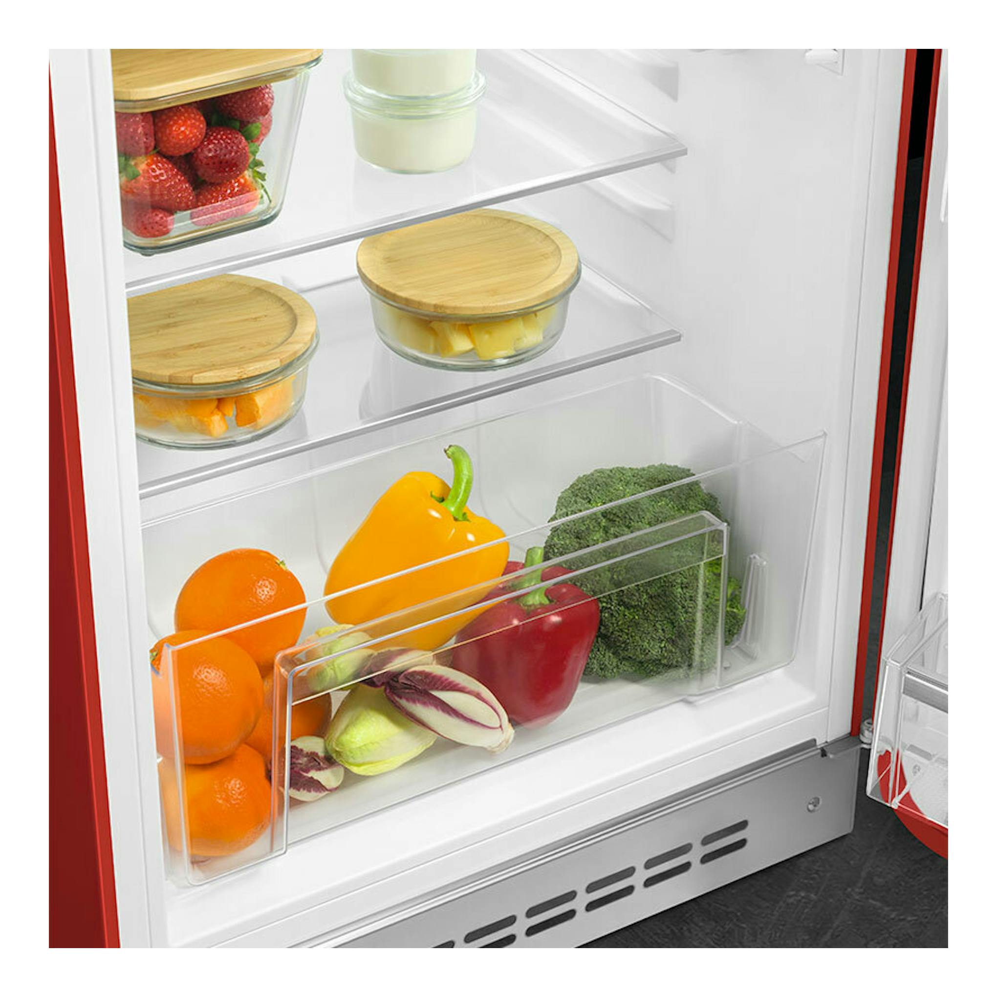 Interior de frigorífico Smeg FAB10RRD6 rojo, con estantes de vidrio y cajón con fruta y verduras.