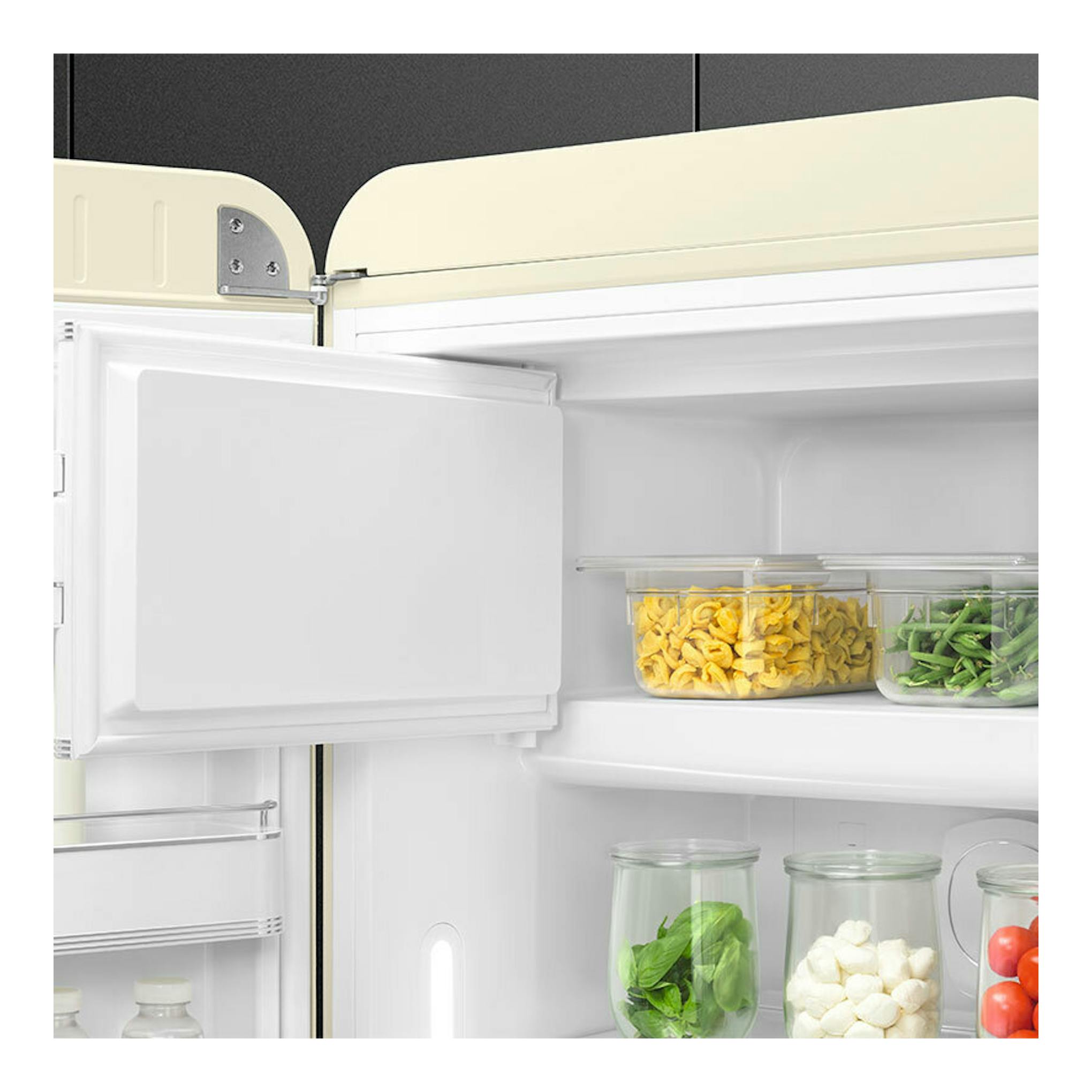 Frigorífico Smeg FAB28LCR6 crema, vista interior con puerta abierta y alimentos en estantes.