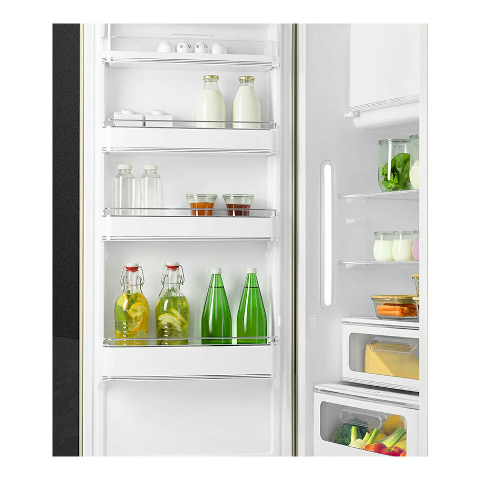 Vista frontal del interior de un frigorífico Smeg FAB28LCR6 crema, con estantes blancos, botellas y tarros.