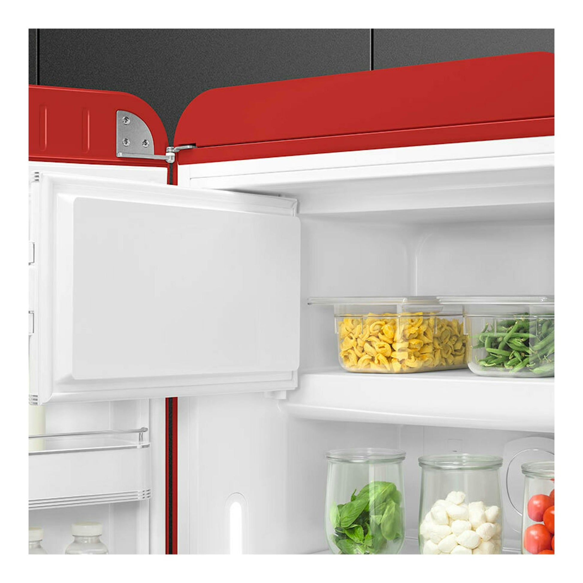 Frigorífico Smeg FAB28LRD6 rojo, vista interior abierta con recipientes de alimentos.