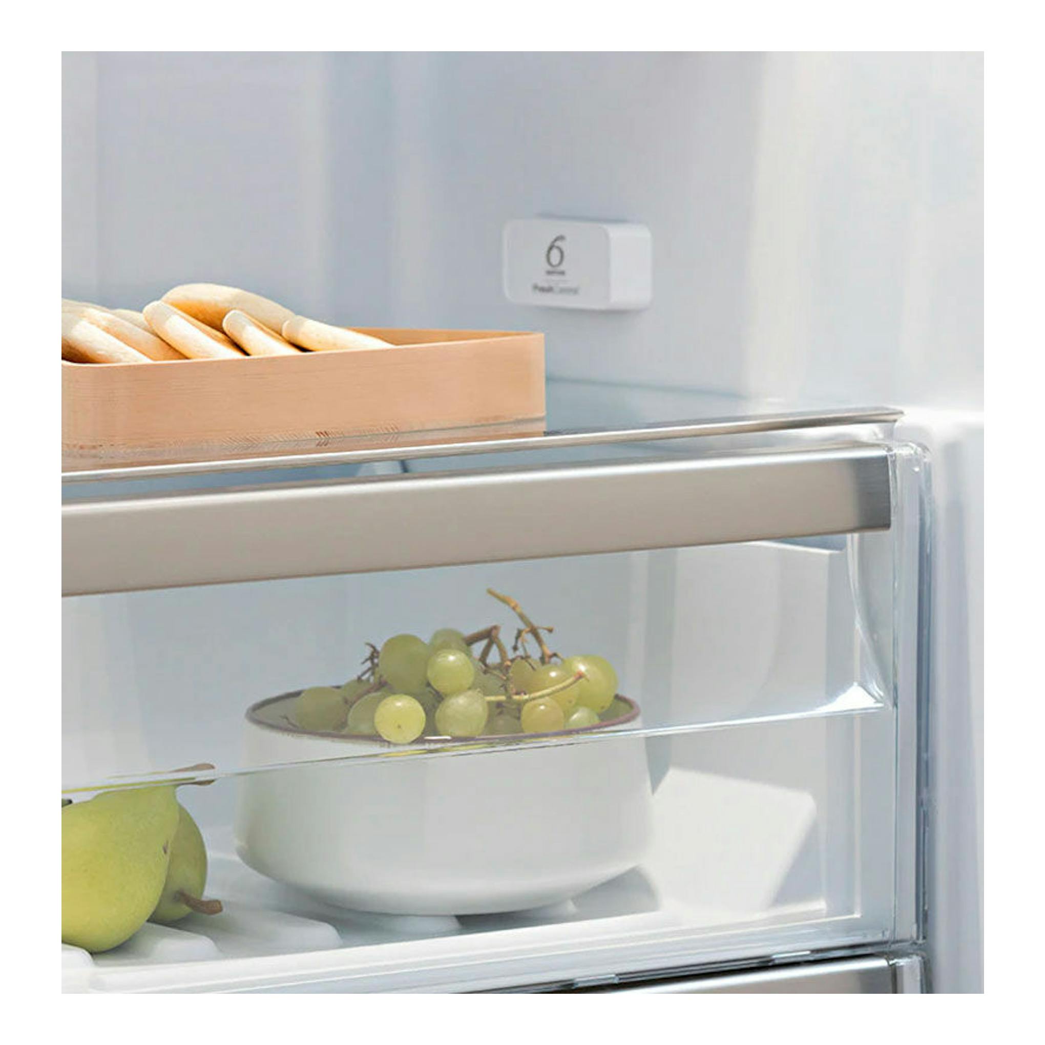 Interior de frigorífico Whirlpool SW8AM2YWR2 blanco, con estantes de cristal, uvas y peras.