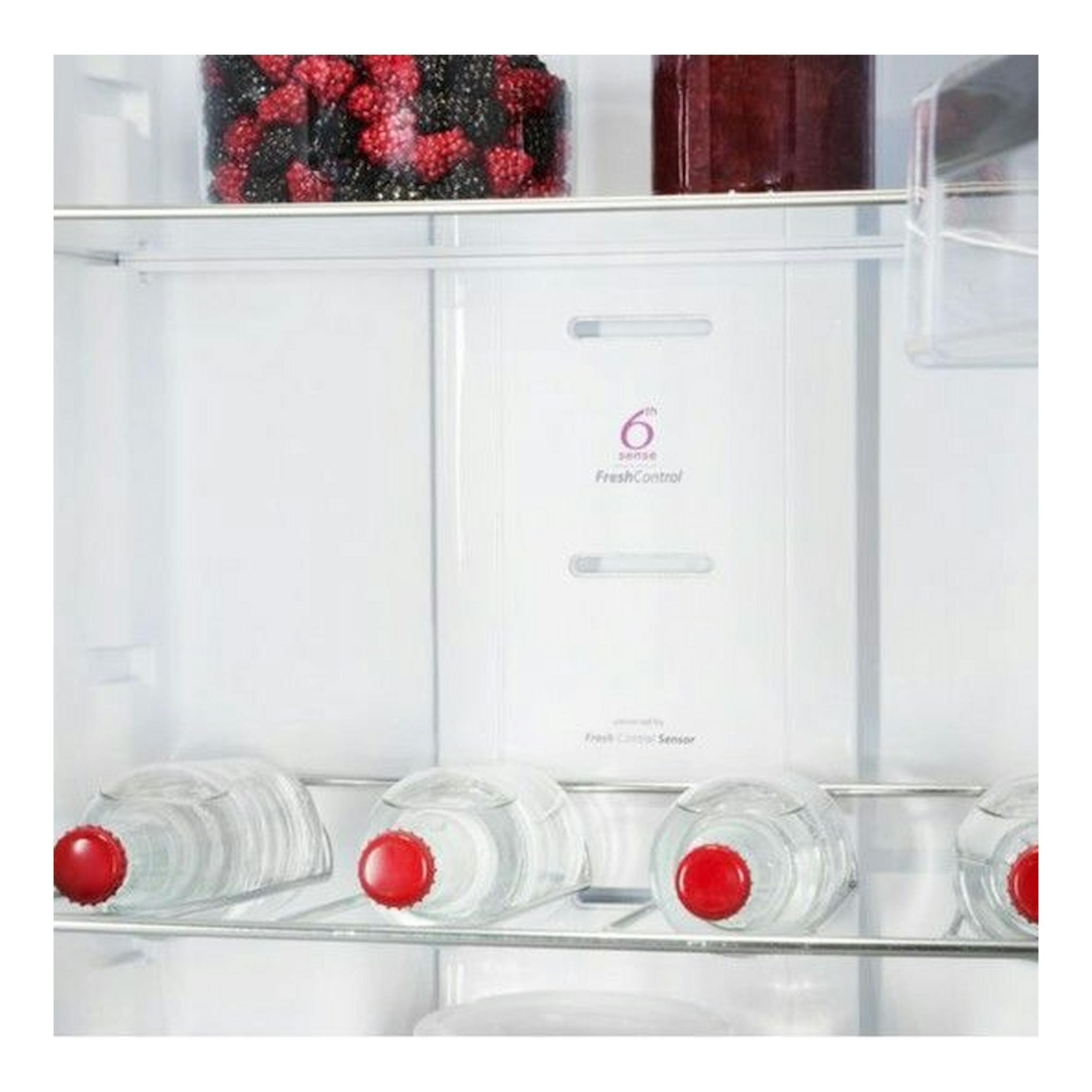 Interior de frigorífico Whirlpool SW8AM2YXR2 Inox, vista frontal, con botellas en baldas y frutos rojos arriba.