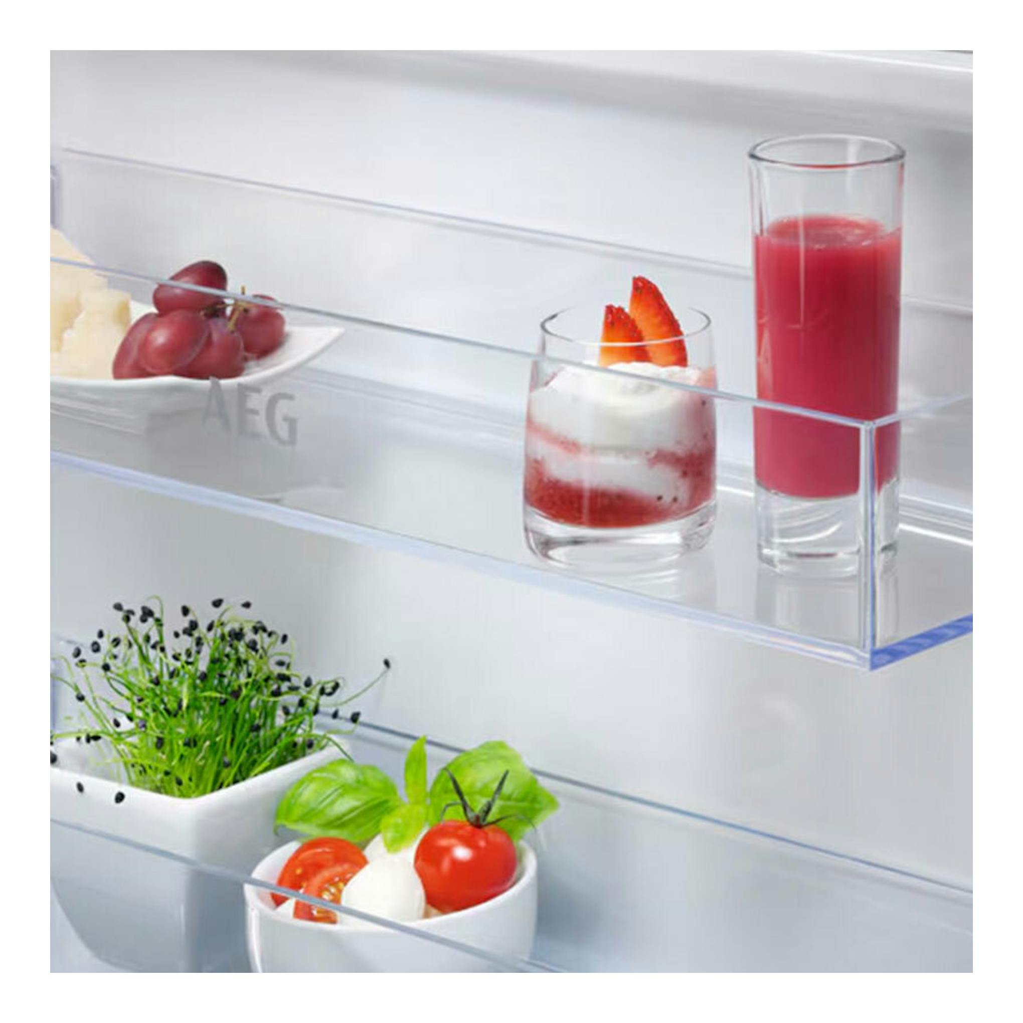 Interior de frigorífico AEG OSD5S161ES con estantes de cristal y vasos de bebida, fruta y postre.