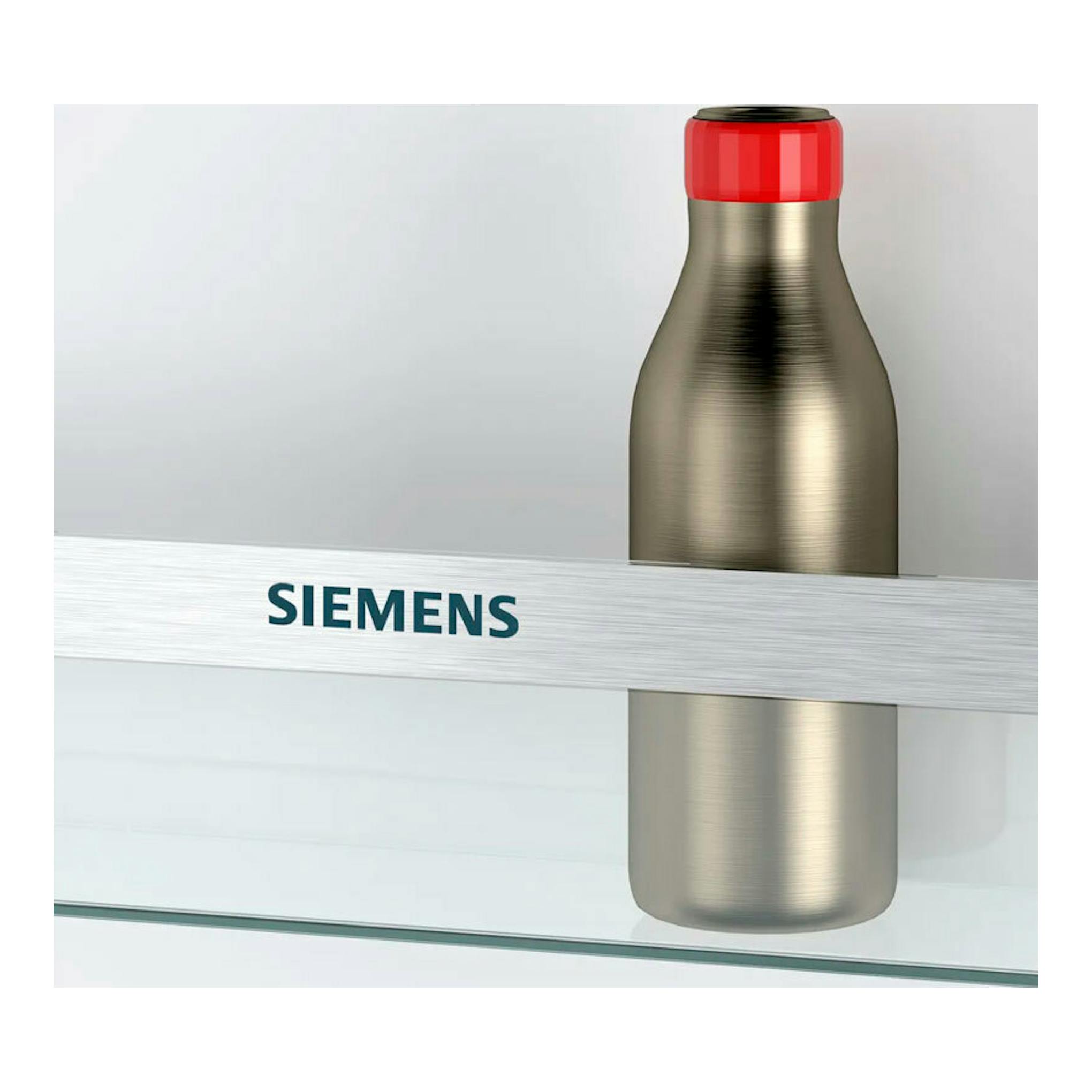 Primer plano de una botella metálica con tapón rojo y banda plateada con logotipo Siemens.