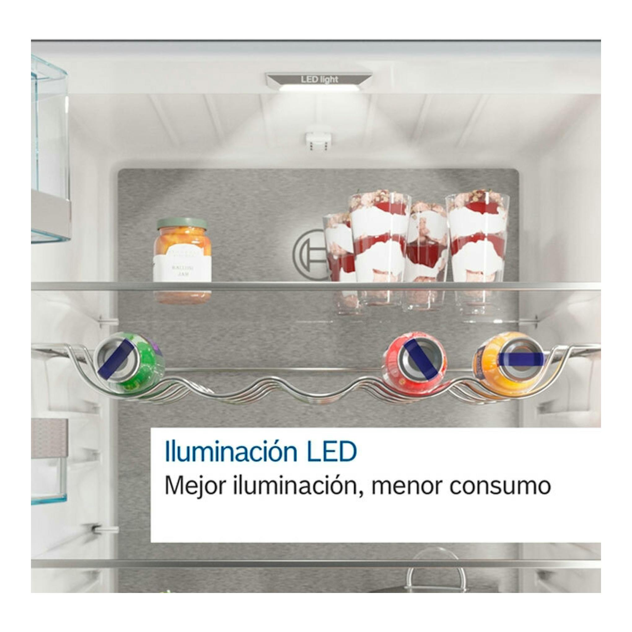 Interior de frigorífico Bosch KFN96APEA Inox, vista frontal con estantes, vasos y latas, iluminación LED.