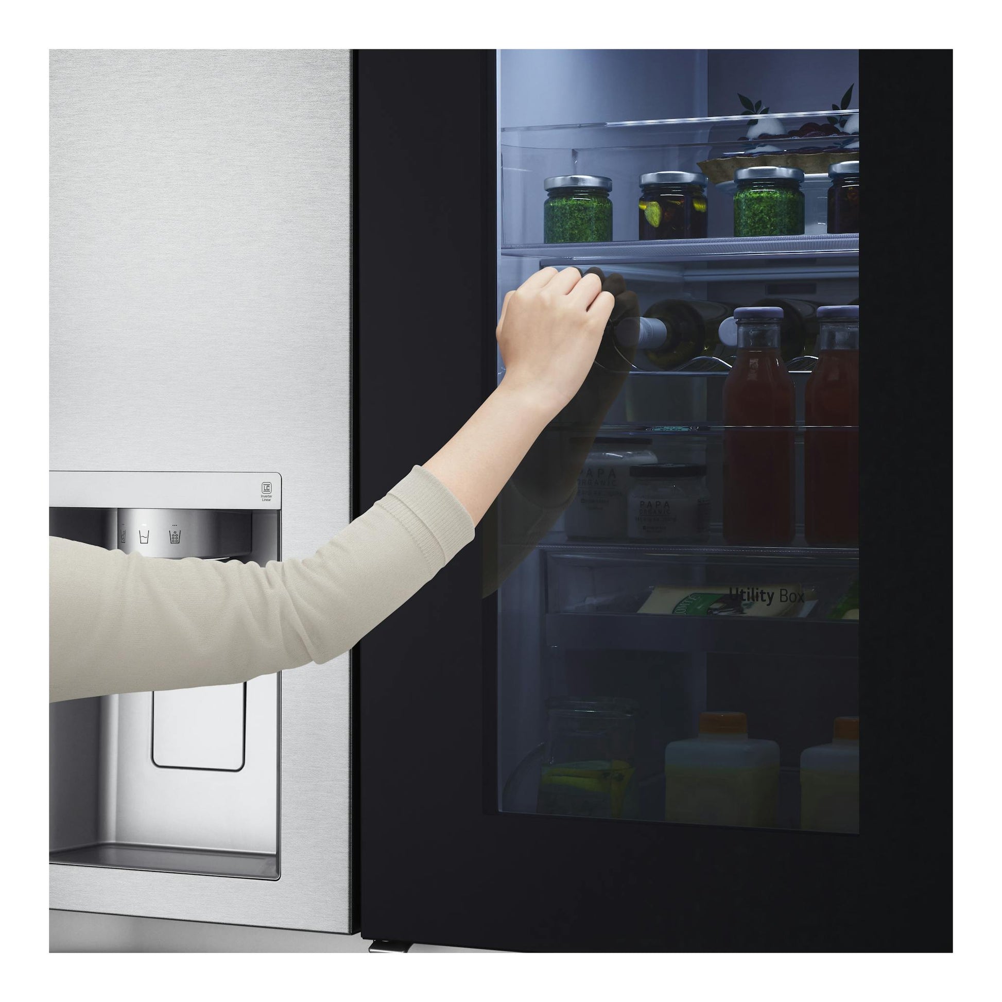 Frigorífico americano LG GSXV90MBAE en acero inoxidable y negro, con puerta transparente y una mano abriéndolo.