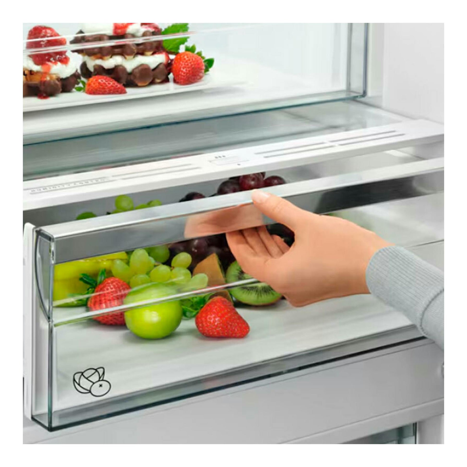 Frigorífico combi AEG ORC8M361EE negro, primer plano del cajón transparente con fruta y una mano abriéndolo.
