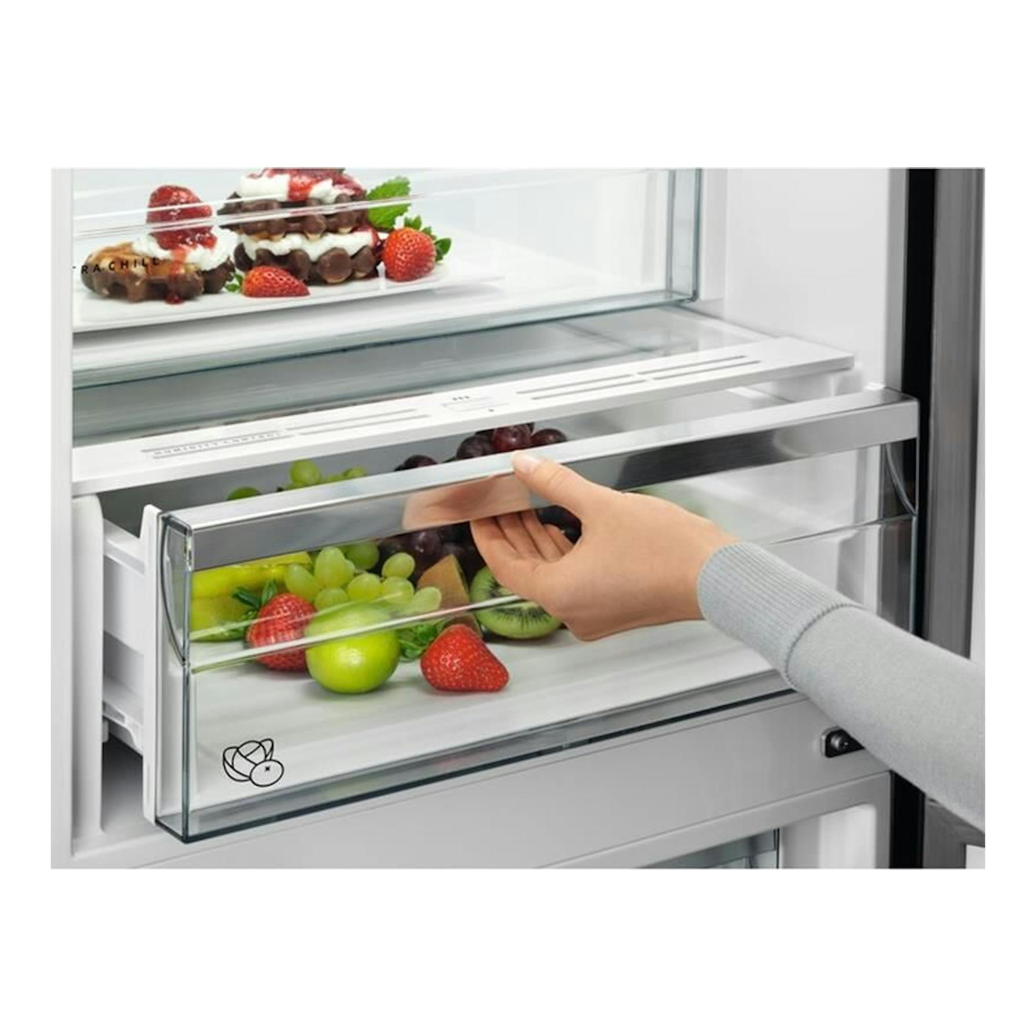 Frigorífico combi AEG RCB736D3MW blanco, vista interior de cajón abierto con fruta y una mano tirando del tirador.