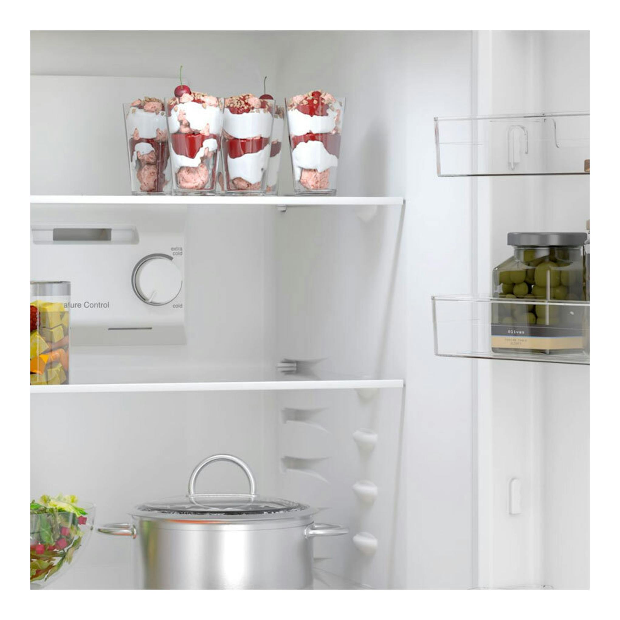 Interior de frigorífico combi Balay 3KFE551WI blanco con estantes y alimentos en los compartimentos.