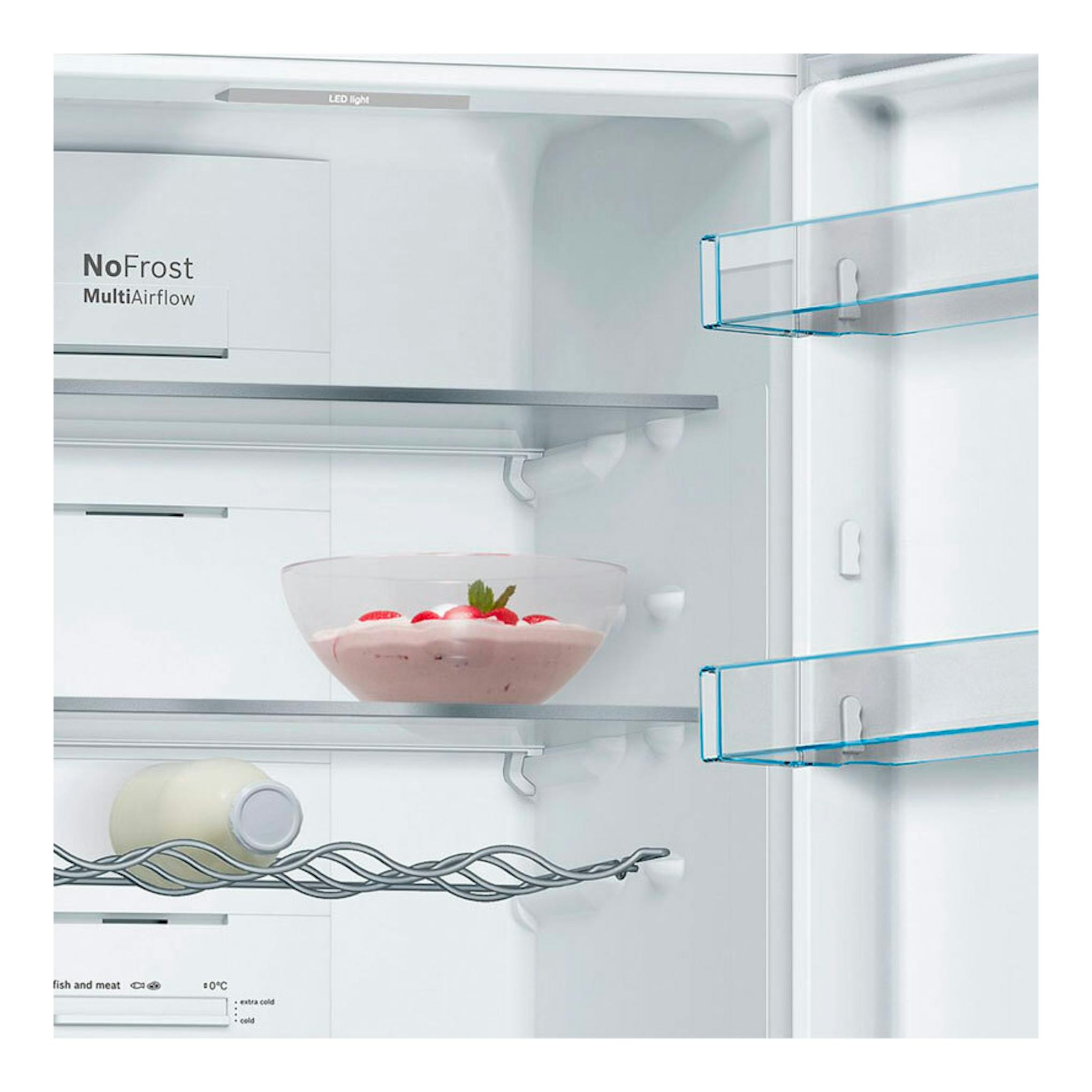 Bosch KGN36VLDB, vista frontal del interior de frigorífico combi blanco con estantes de cristal, cuenco y botella.