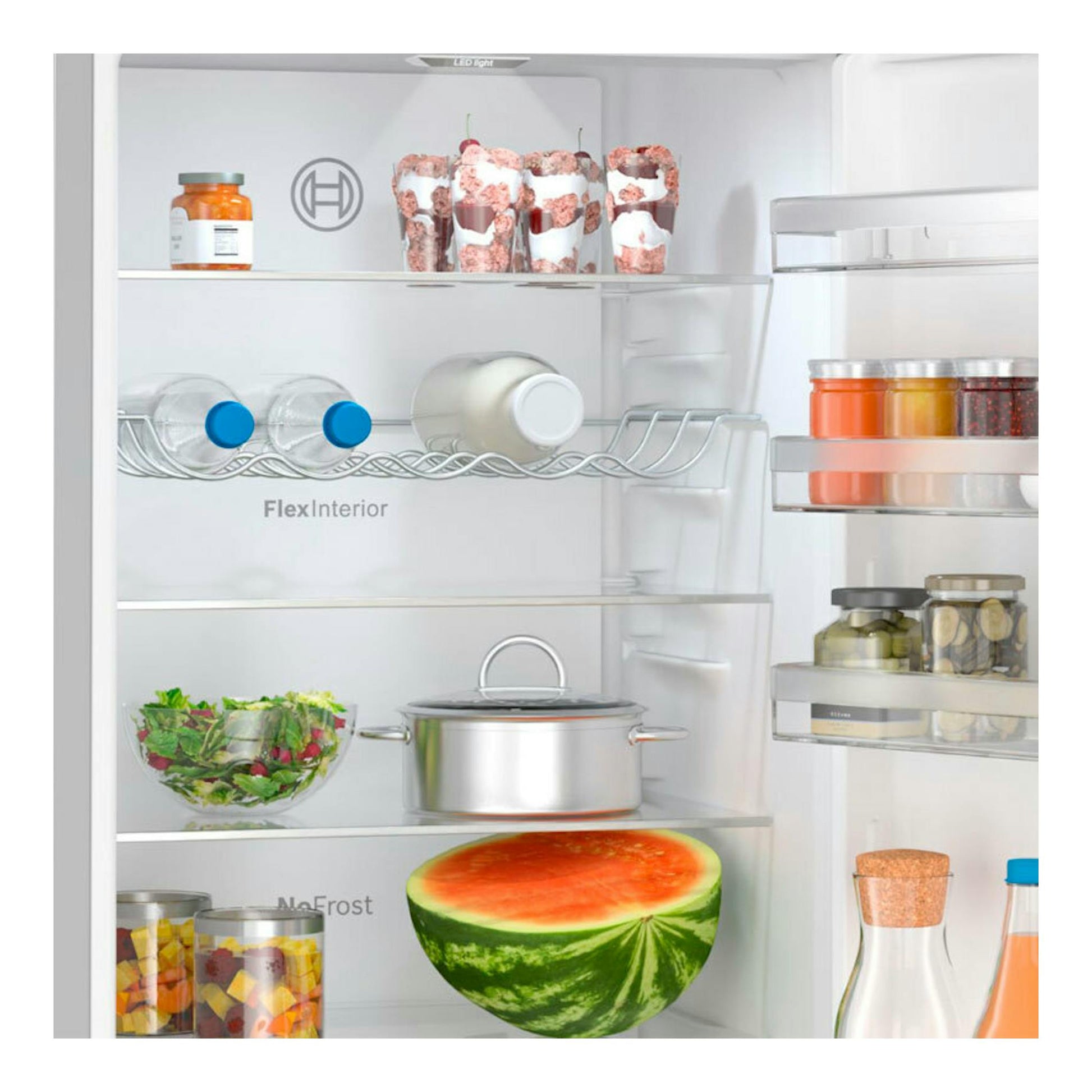Interior de un frigorífico combi Bosch KGN392ICF Inox, vista frontal, con estantes y alimentos en recipientes.