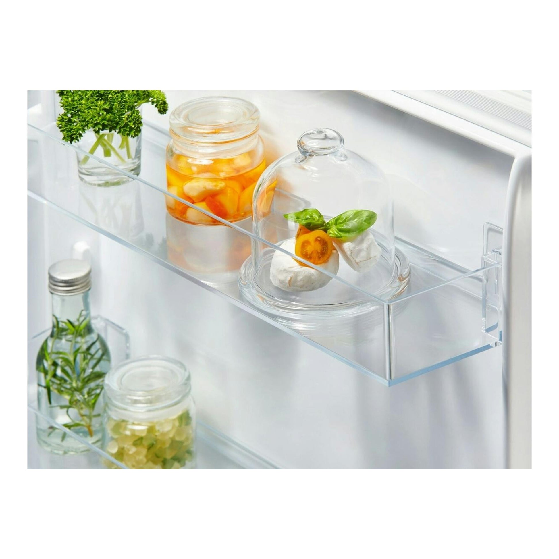 Electrolux ENA7CE18S1: interior de frigorífico blanco con estantes de cristal, tarros y alimentos bajo campanas.