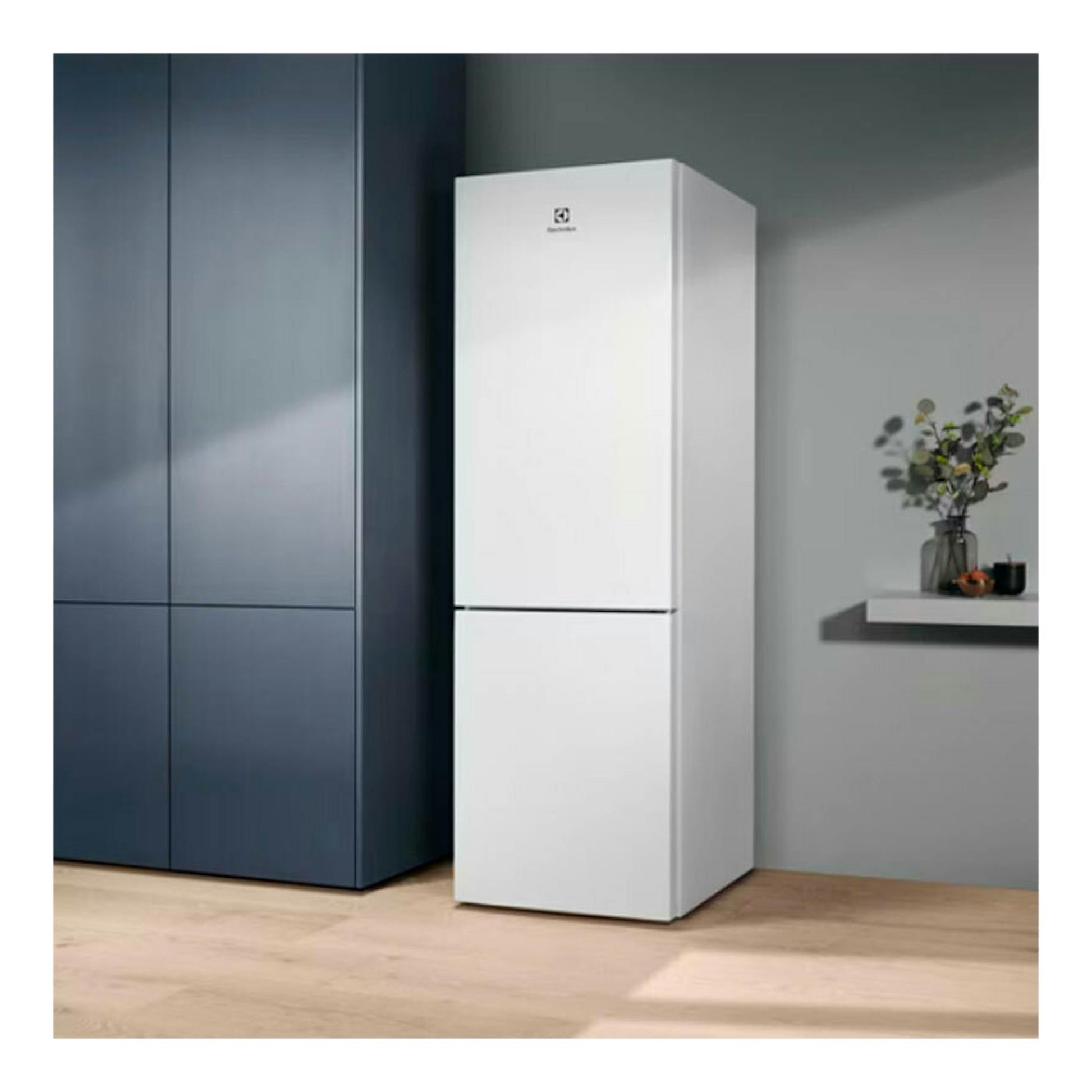 Frigorífico combi Electrolux LNT5ME32W1 blanco, vista frontal, junto a muebles azules.