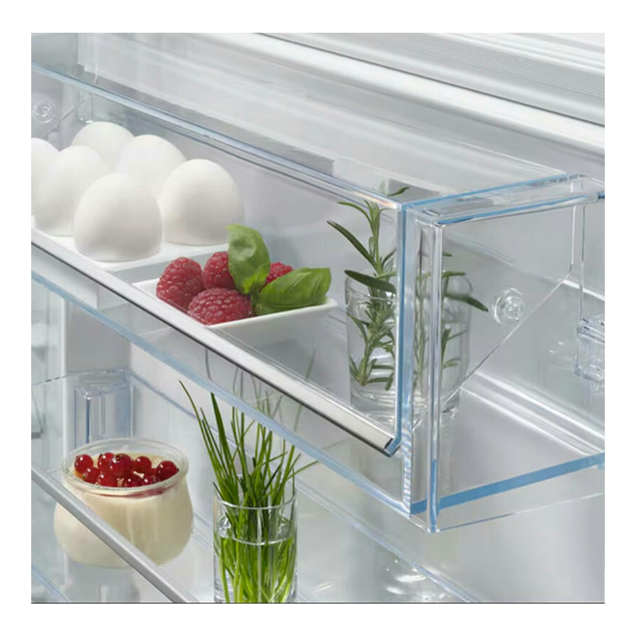 Interior de frigorífico combi integrable AEG NSC7P751ES, con estantes transparentes, huevos, frambuesas y hierbas.