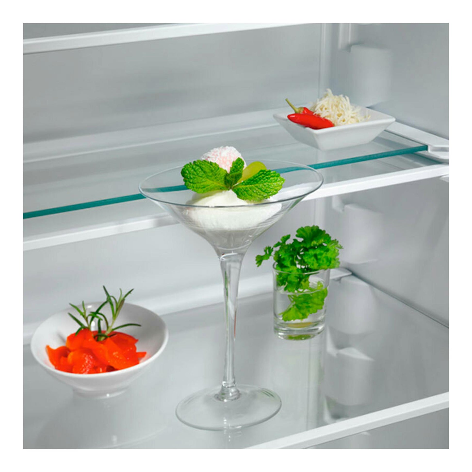 Interior de frigorífico combi integrable AEG OSC7G181ES con estantes de vidrio y cuencos con comida.