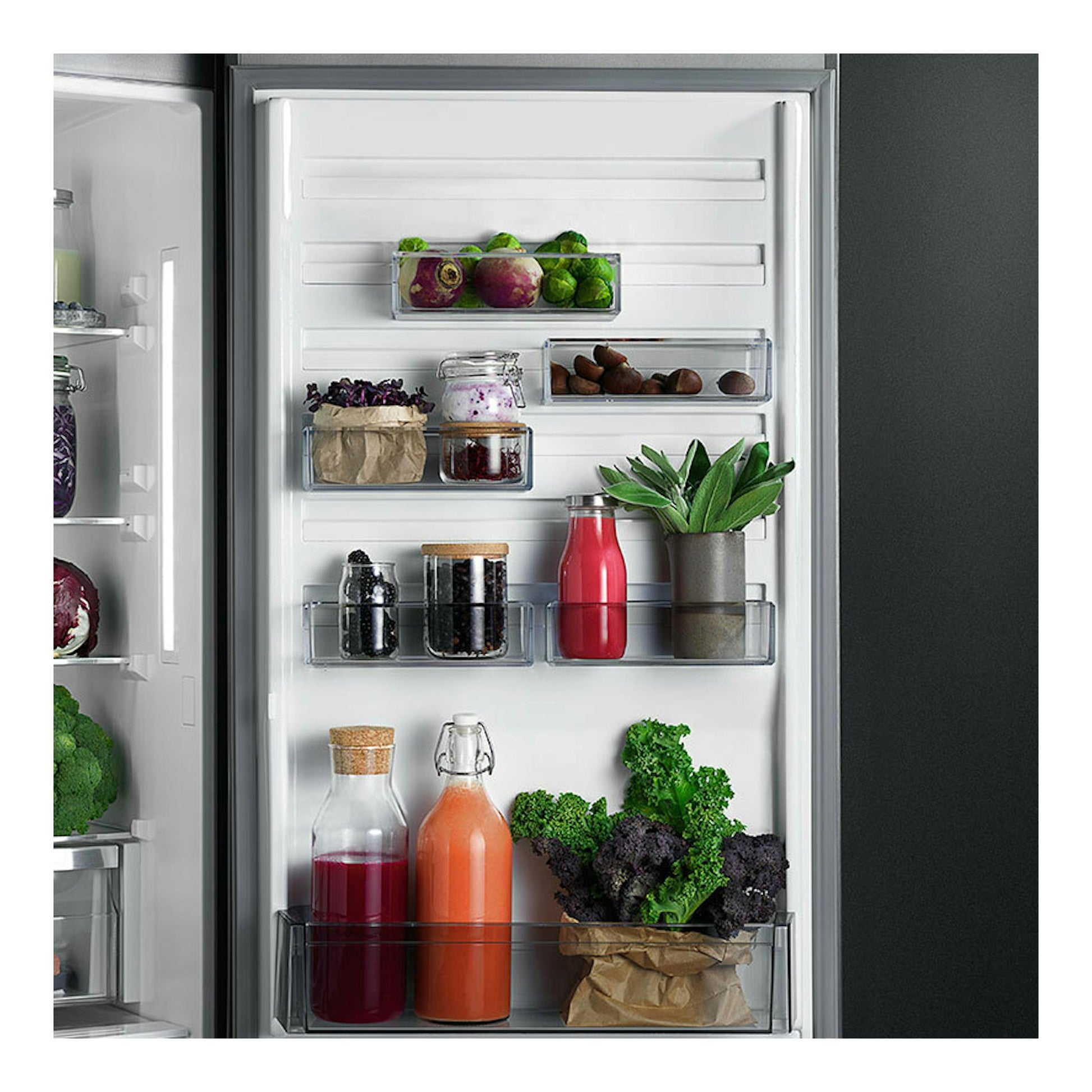 Interior de la puerta de un frigorífico integrable AEG TC6MS19FES, vista frontal, con botellas, tarros y verduras.