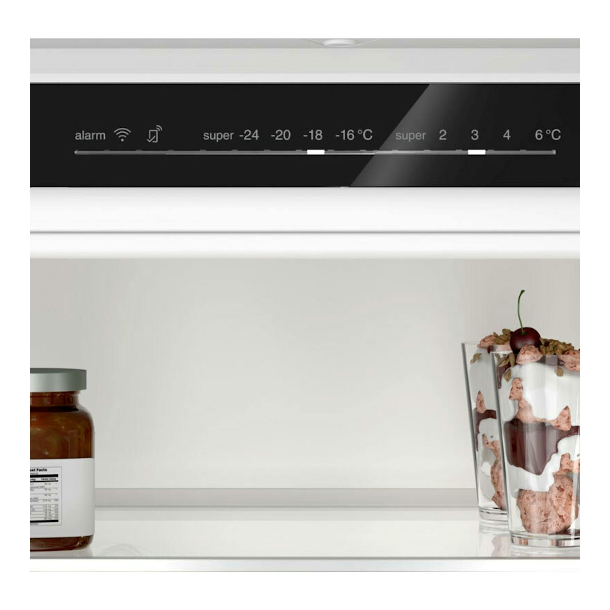 Interior de frigorífico combi Bosch KBN96VFE0, con panel digital negro y alimentos sobre estantes blancos.