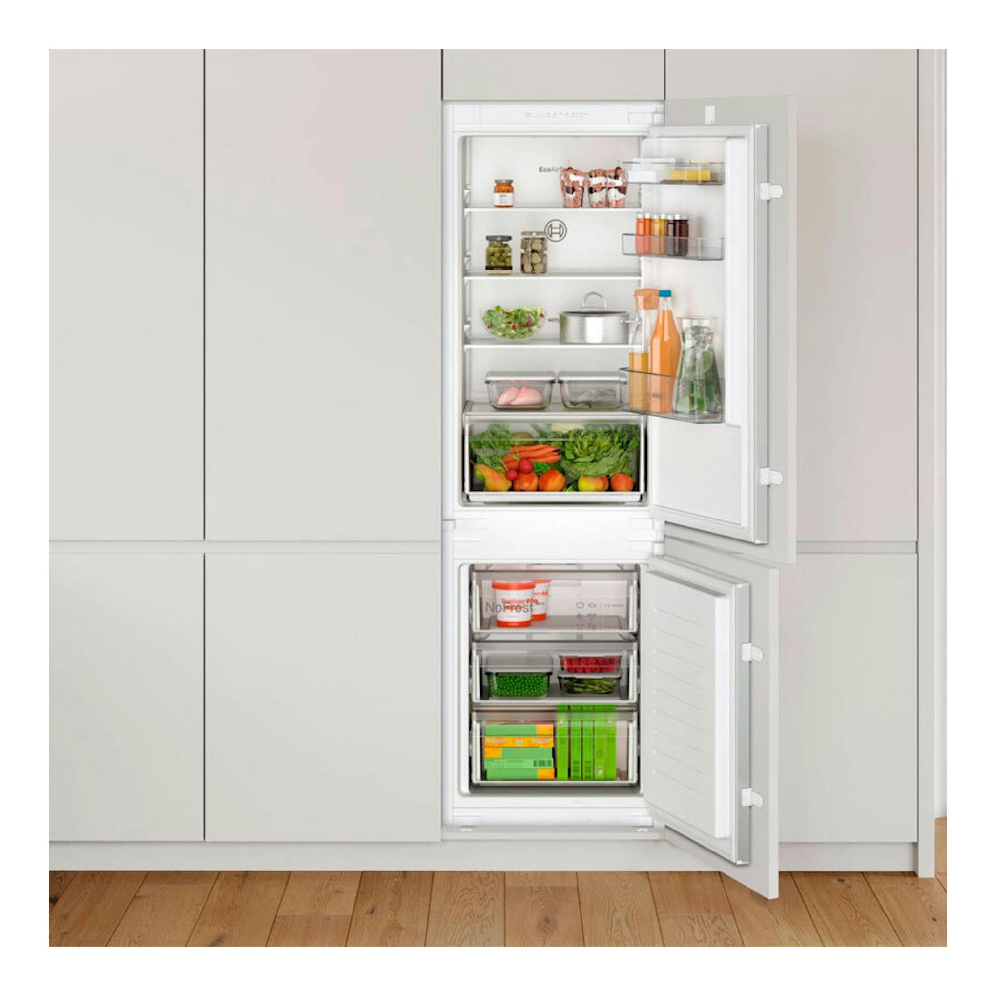 Vista frontal de frigorífico combi integrable Bosch KIN86NSE0 blanco, con puertas abiertas y alimentos.