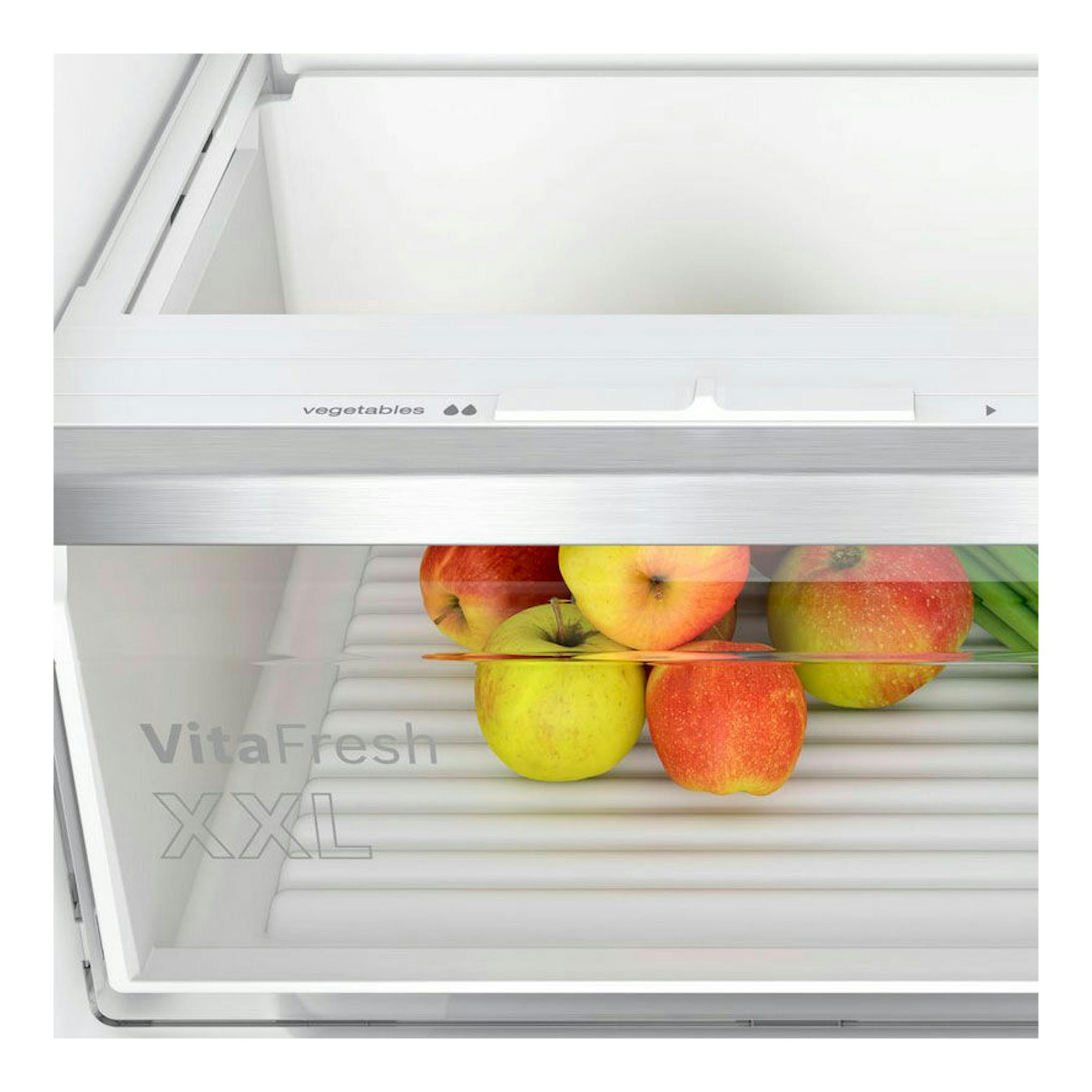 Bosch KIV86VSE0, interior de frigorífico combi blanco con cajón VitaFresh y manzanas, vista frontal.