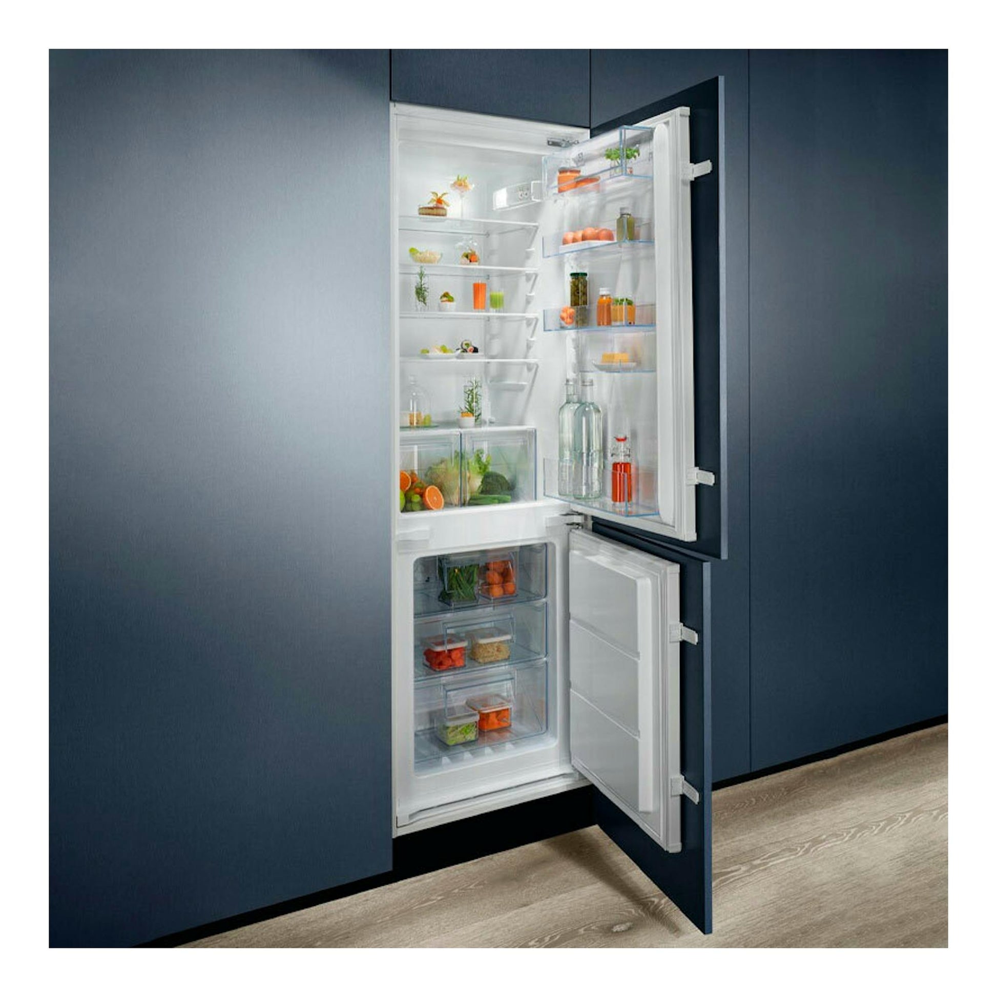 Frigorífico combi integrable Electrolux ENT6NE18S abierto, vista frontal, interior blanco en mueble azul oscuro.