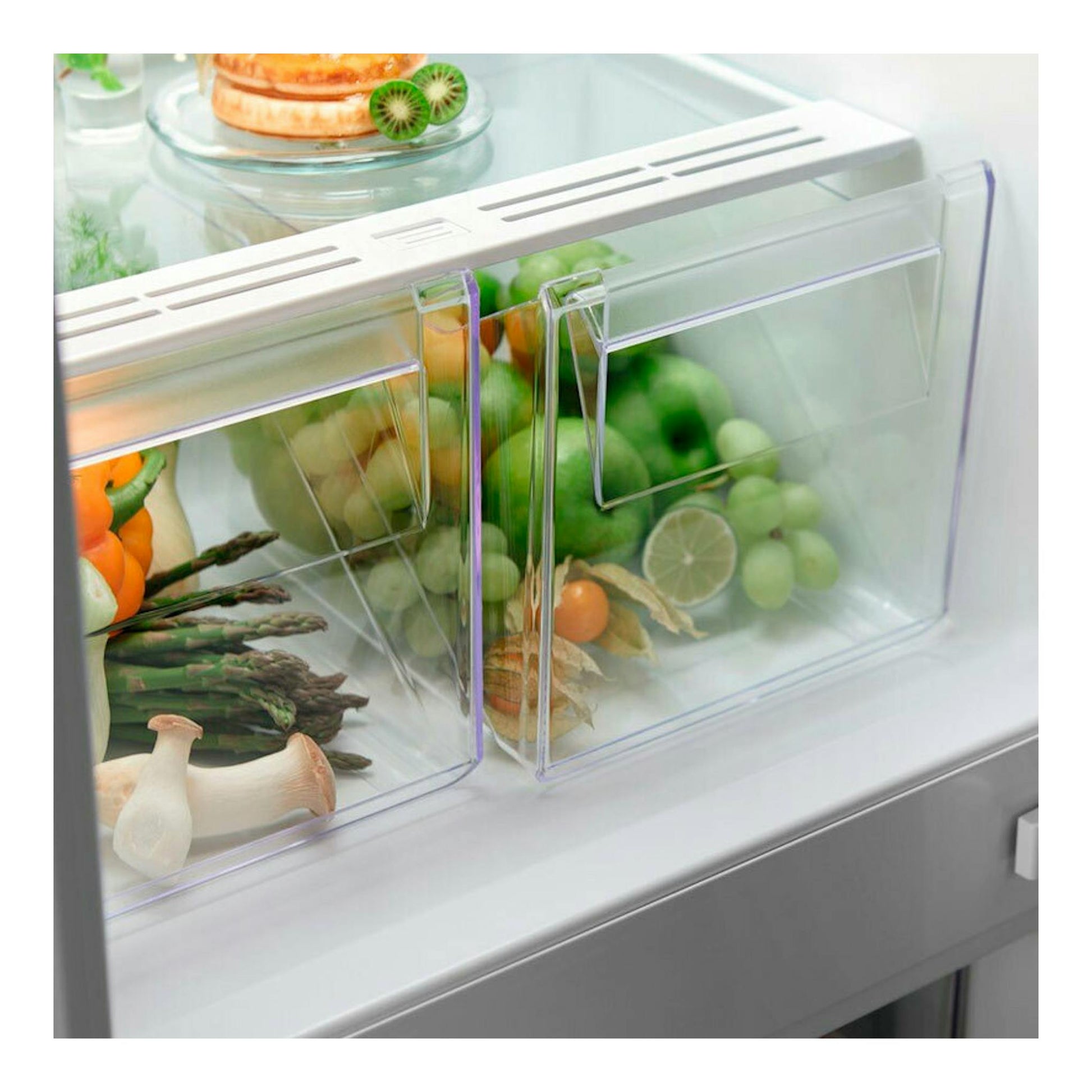 Frigorífico combi integrable Electrolux ENT6NE18S, vista interior en blanco con cajones transparentes y verduras.