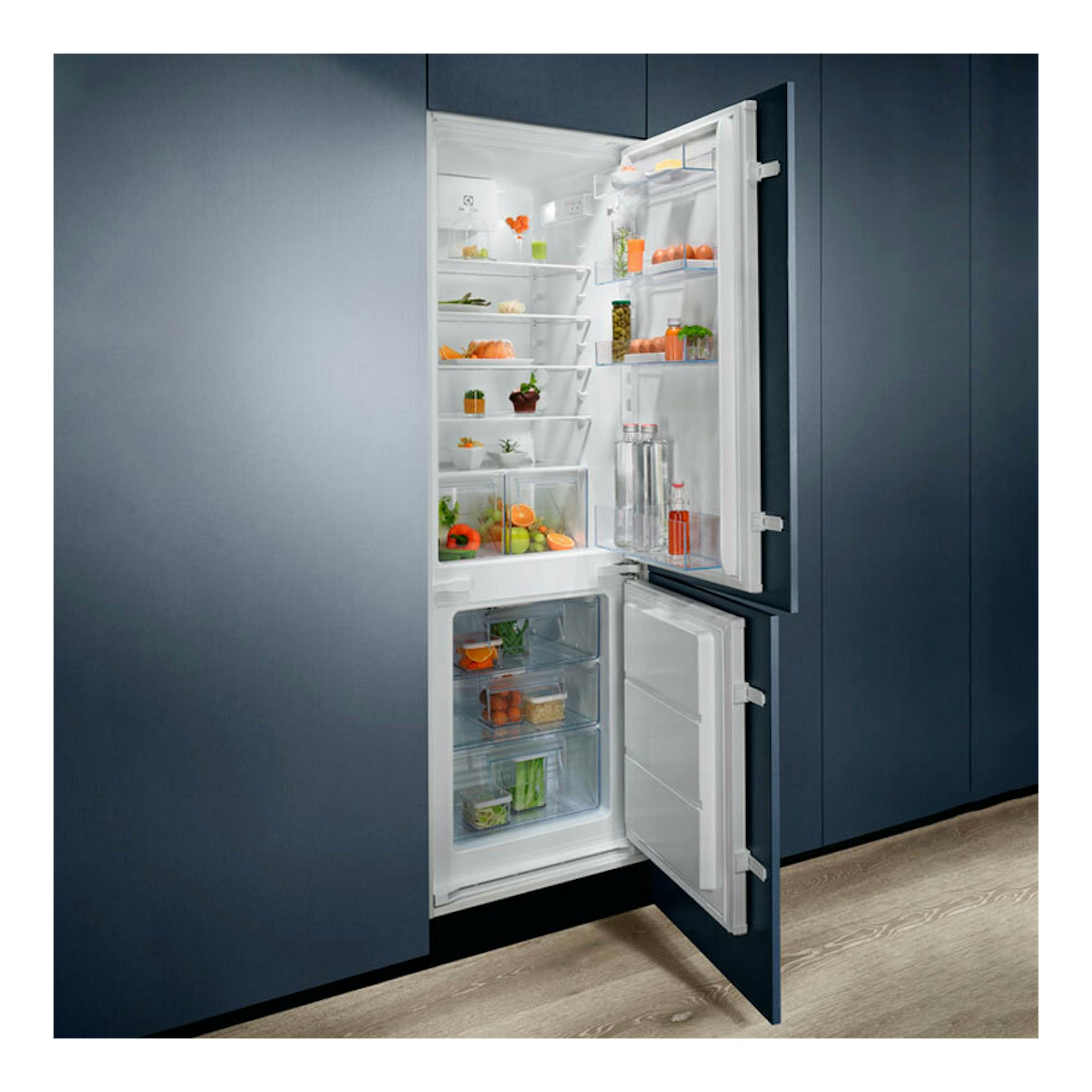 Frigorífico combi integrable Electrolux LND5FE18S abierto, interior blanco con alimentos, empotrado en mueble azul.