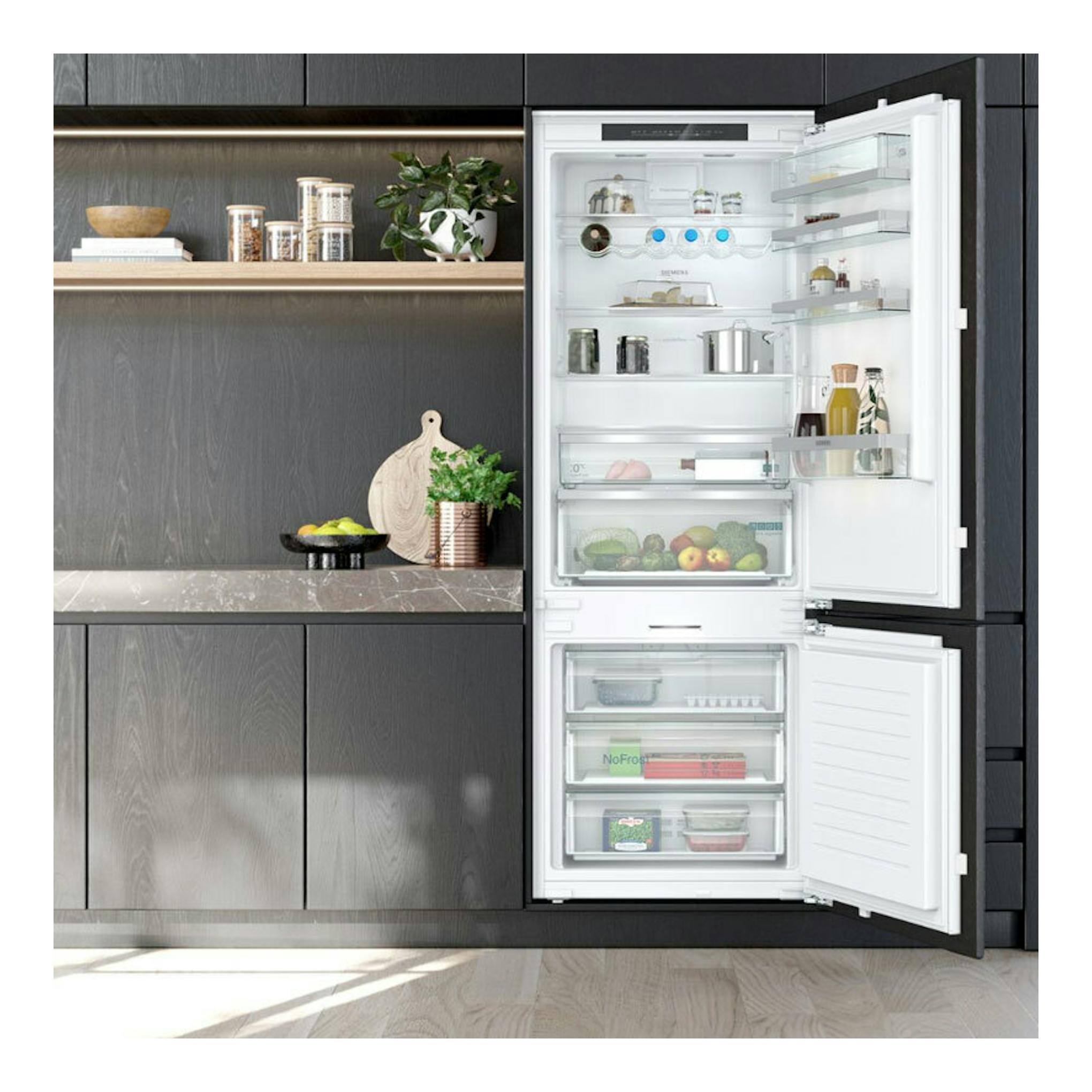 Frigorífico combi integrable Siemens KB96NADD0, abierto en cocina moderna, interior blanco y puertas negras.