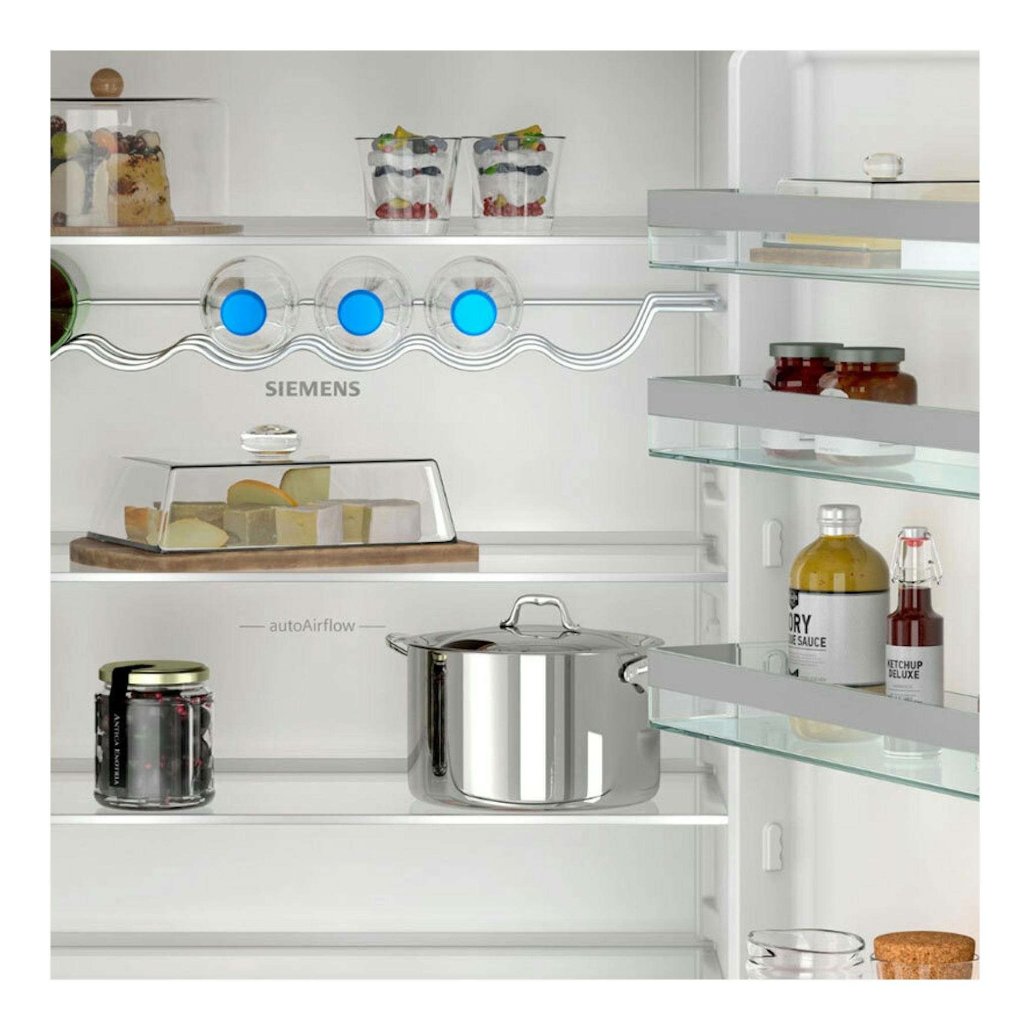 Interior frontal de frigorífico combi integrable Siemens KB96NVFE0, con estantes de cristal y alimentos.