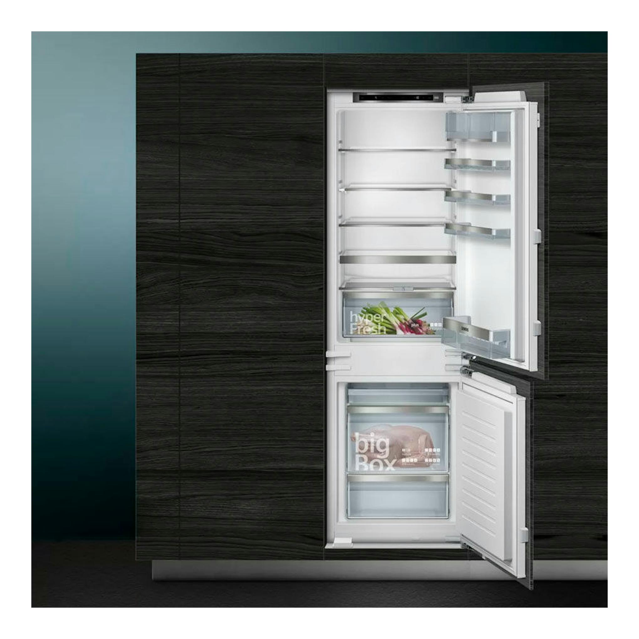 Frigorífico combi integrable Siemens KI86SAFE0, vista frontal con puertas abiertas en mueble oscuro.