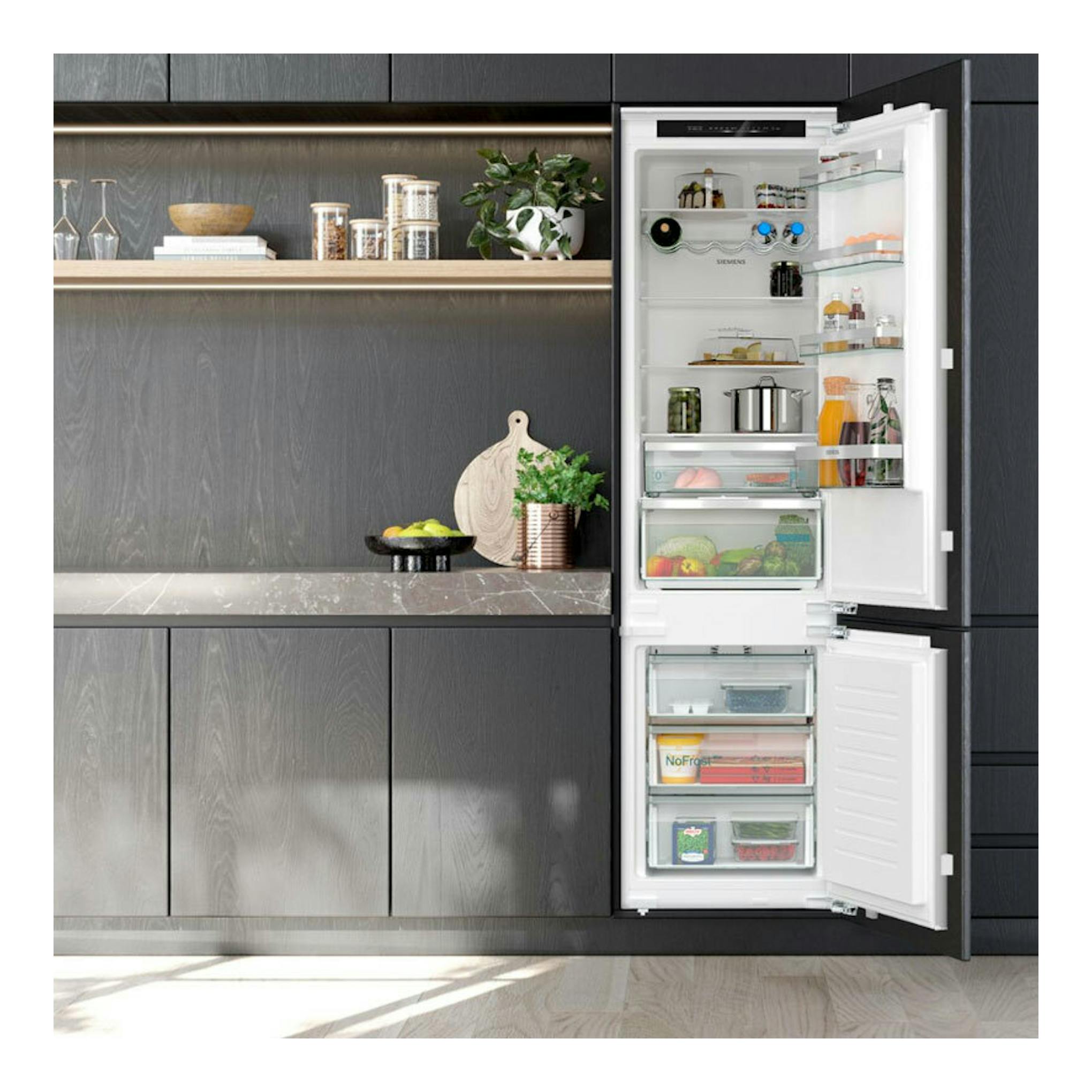 Frigorífico combi integrable Siemens KI96NVFD0, vista frontal con puertas abiertas y congelador inferior.