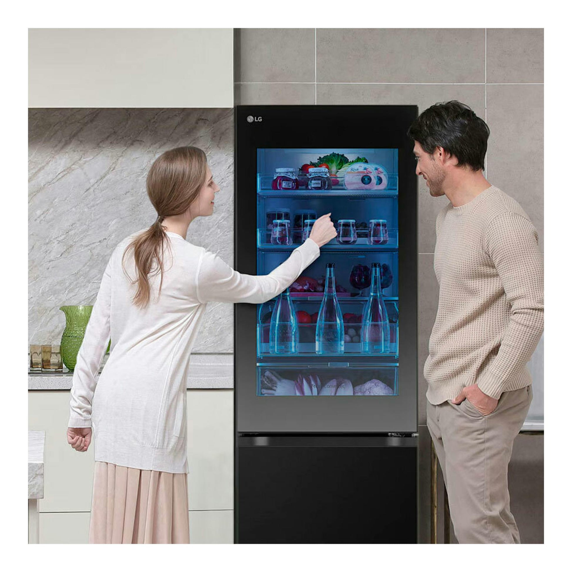 Frigorífico combi LG GBG5160CEV negro, vista frontal, con puerta de cristal y dos personas observándolo.
