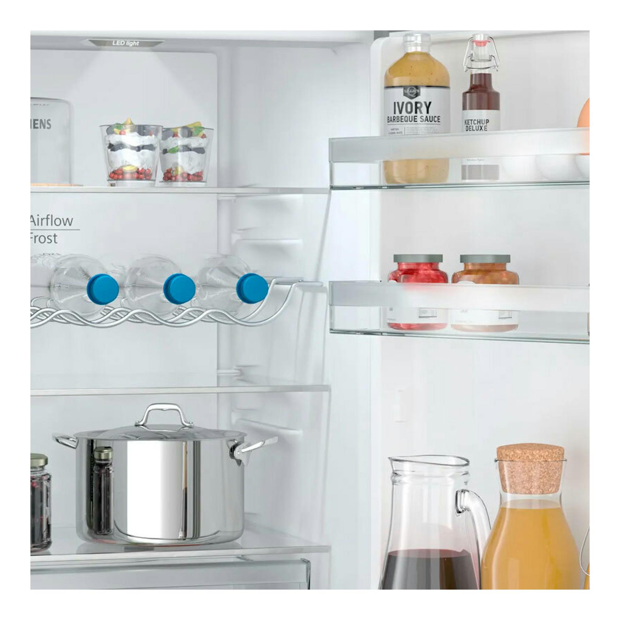 Vista interior del frigorífico combi Siemens KG36N2ICF inox con estantes, botellas, tarros y una olla.