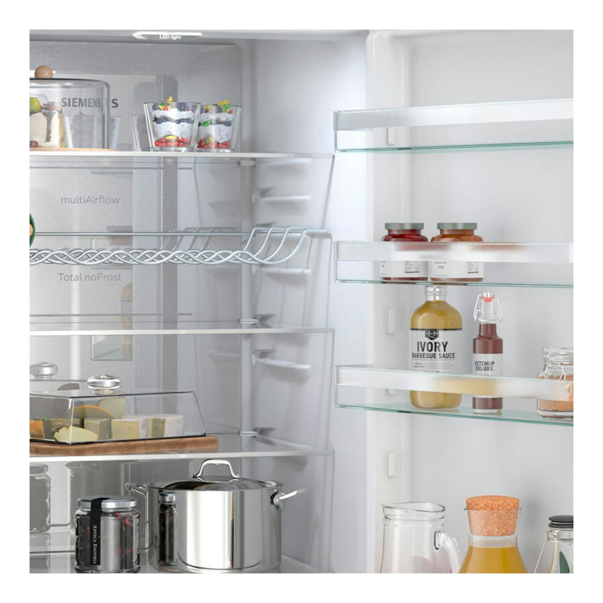 Interior de frigorífico combi Siemens KG39NVWDG blanco, vista frontal del interior con estantes y alimentos.