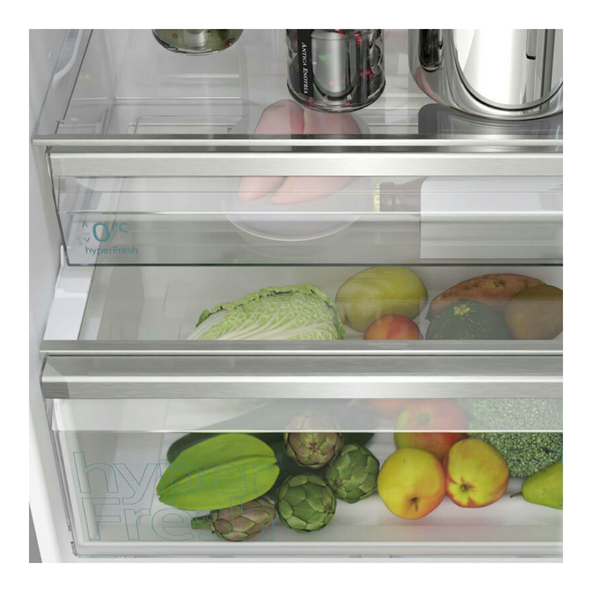 Vista frontal del interior de un frigorífico combi Siemens KG49NAICT Inox, con cajones de cristal y verduras.