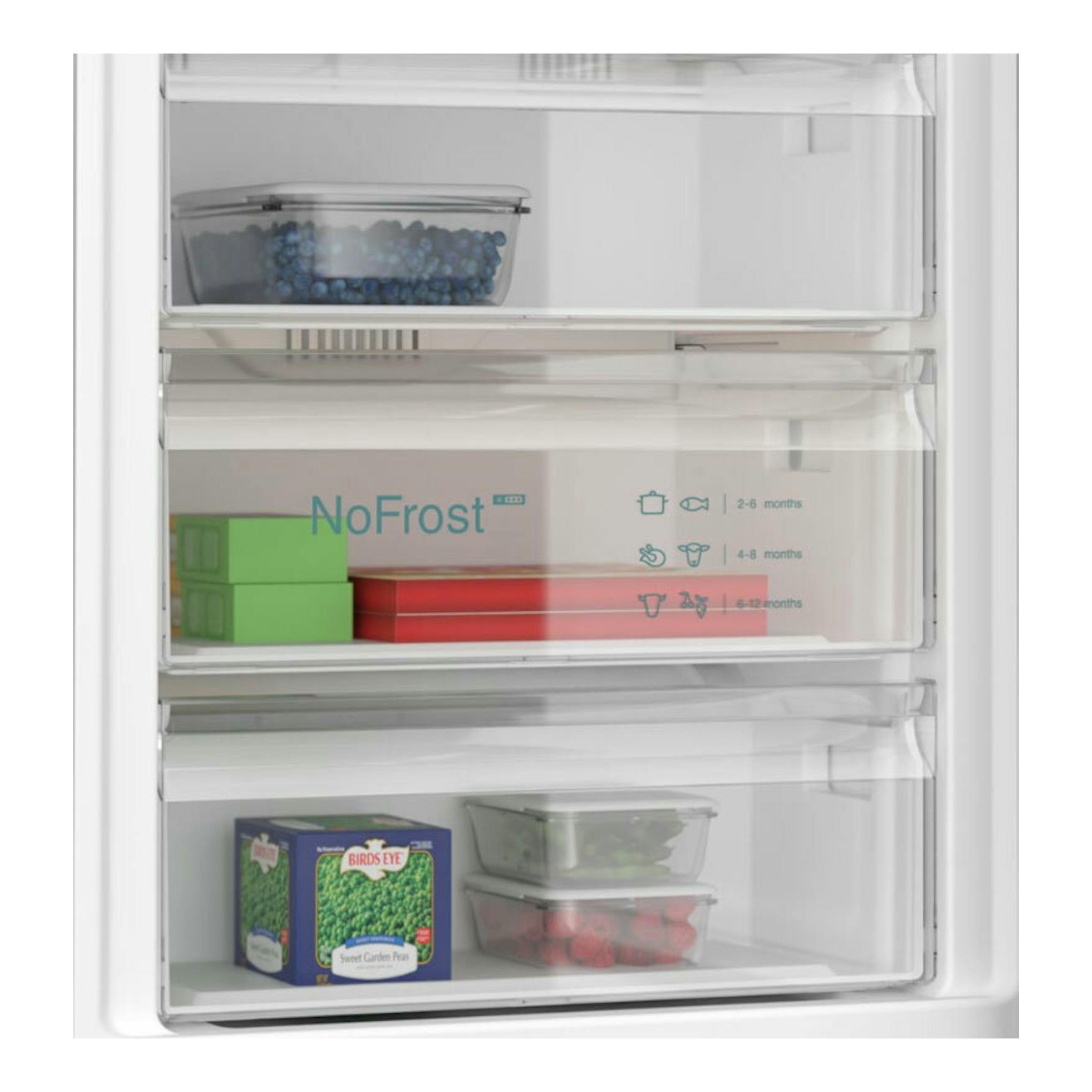 Interior de frigorífico combi Siemens KG49NAICT inox, vista interior con cajones NoFrost y alimentos congelados.