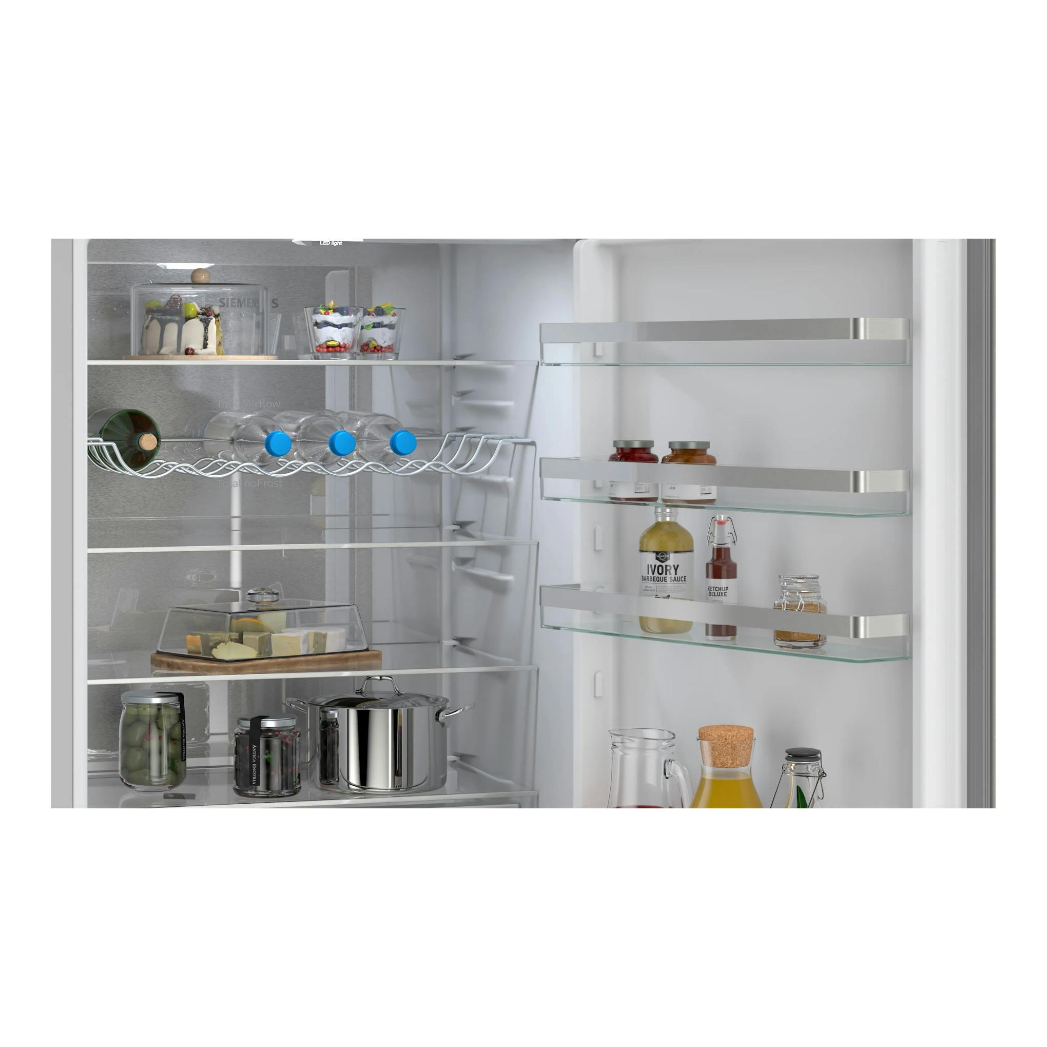 Interior de frigorífico Siemens KG49NVICG, vista frontal, con estantes de cristal y botellas.
