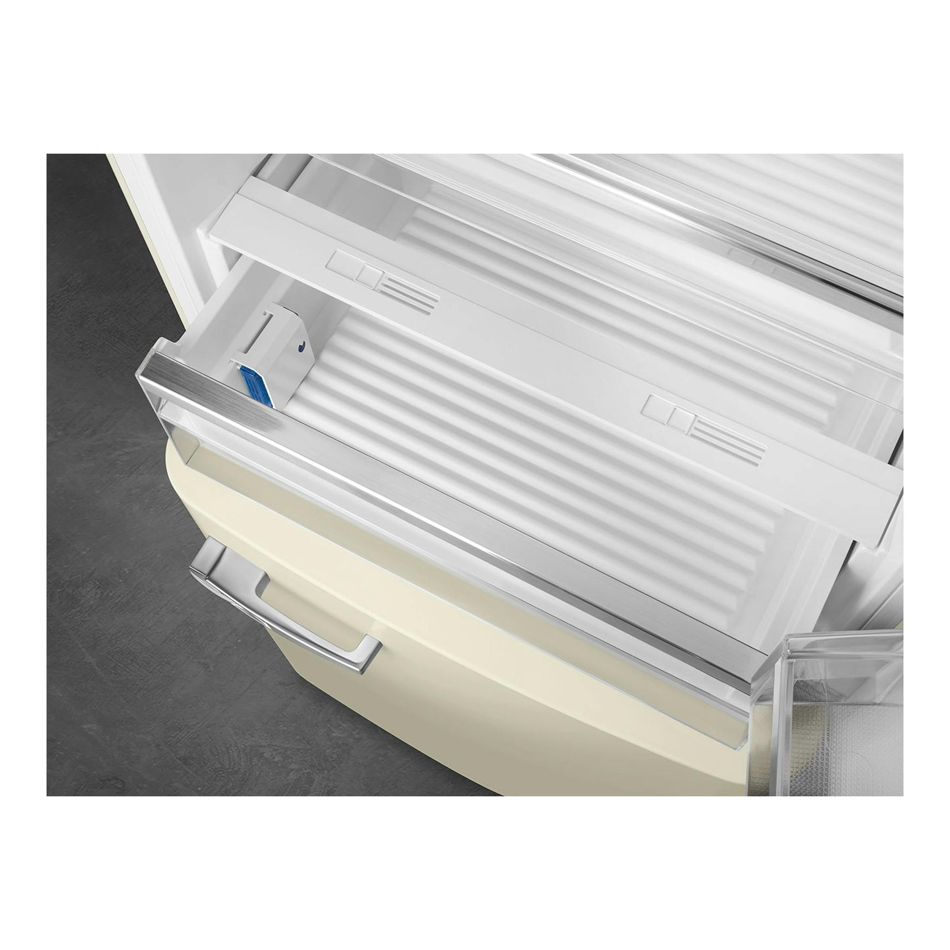 Frigorífico combi Smeg FAB38RCR6 crema, vista inclinada del interior con cajones y baldas abiertas.