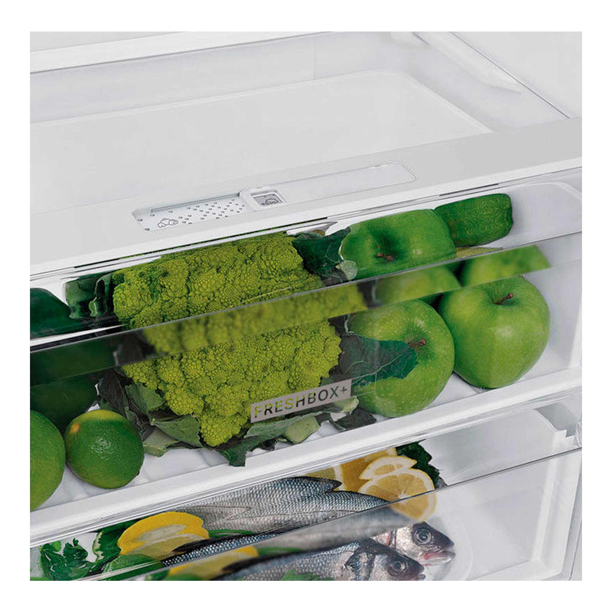 Interior de frigorífico combi Whirlpool W7 821O W blanco, con verduras, manzanas y pescado en cajones.