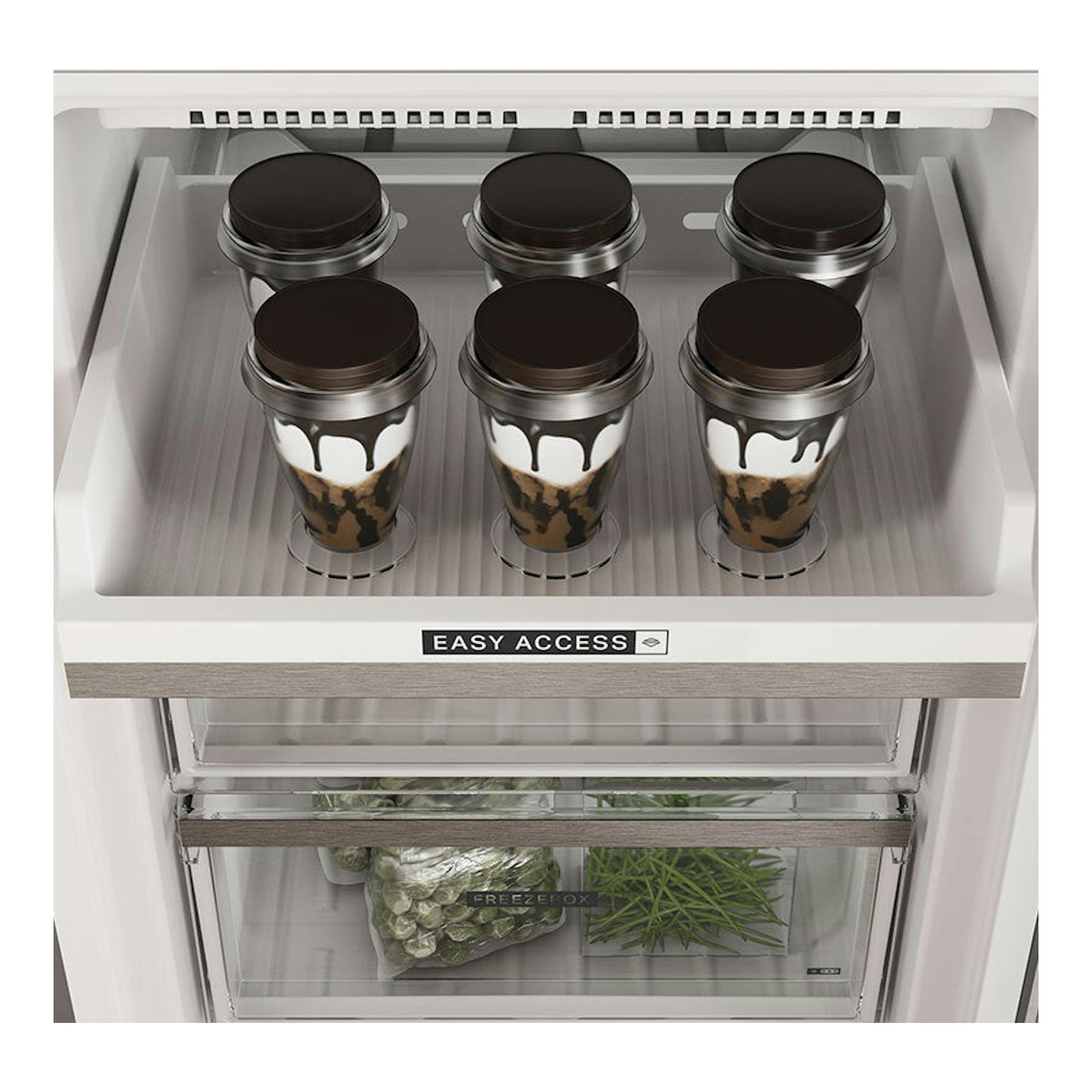 Vista frontal del interior de un frigorífico combi Whirlpool W7X94TSX Inox, con vasos y verduras.