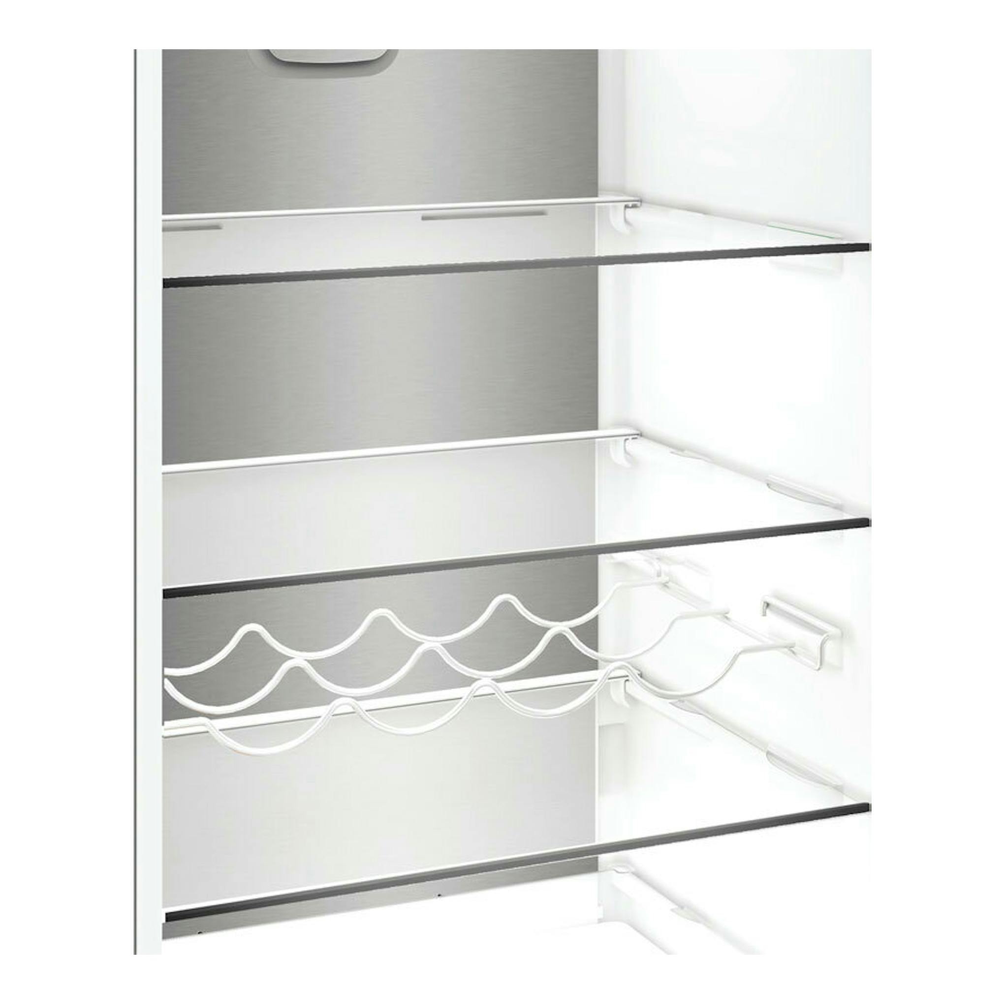 Interior de frigorífico combi Whirlpool WHK26403XP6E en inox, con baldas de cristal y botellero, vista frontal.