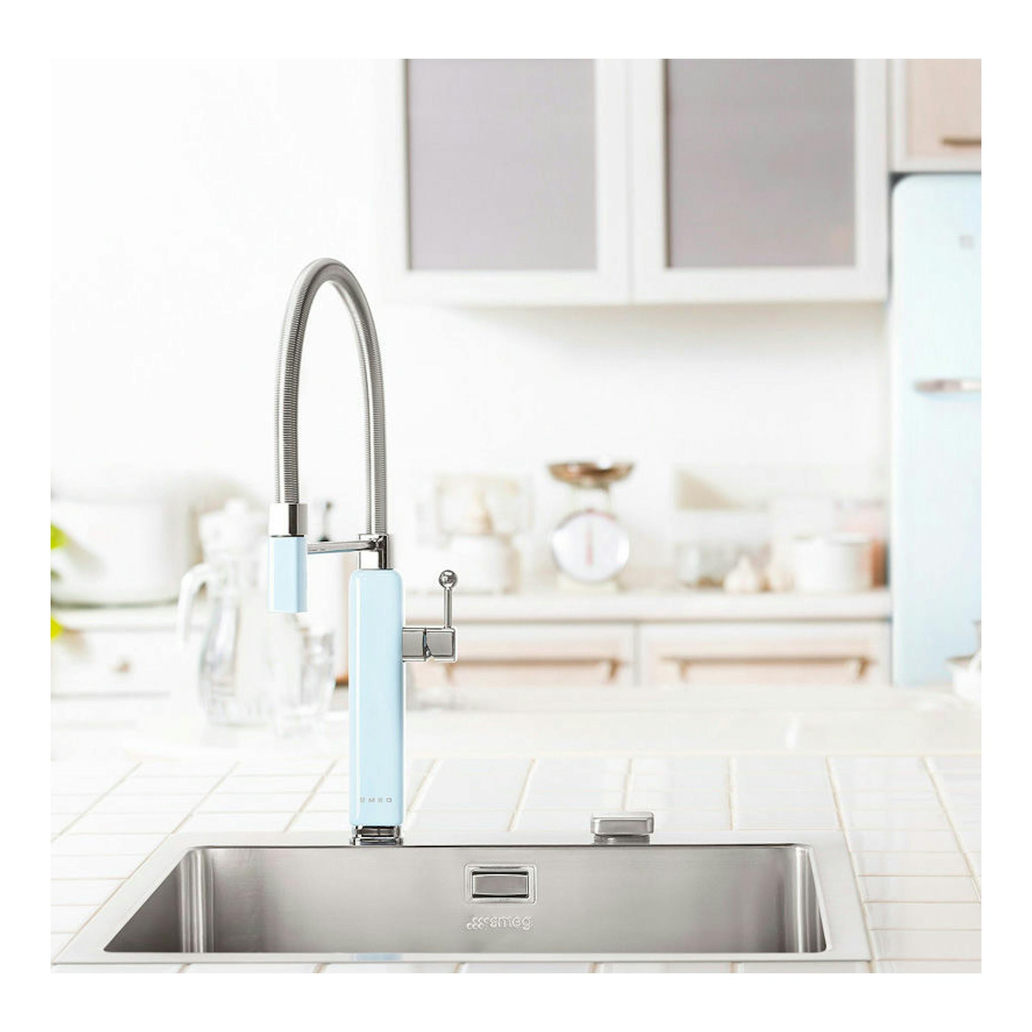 Grifo de cocina Smeg MDF50PB azul claro, vista frontal sobre fregadero de acero inoxidable.