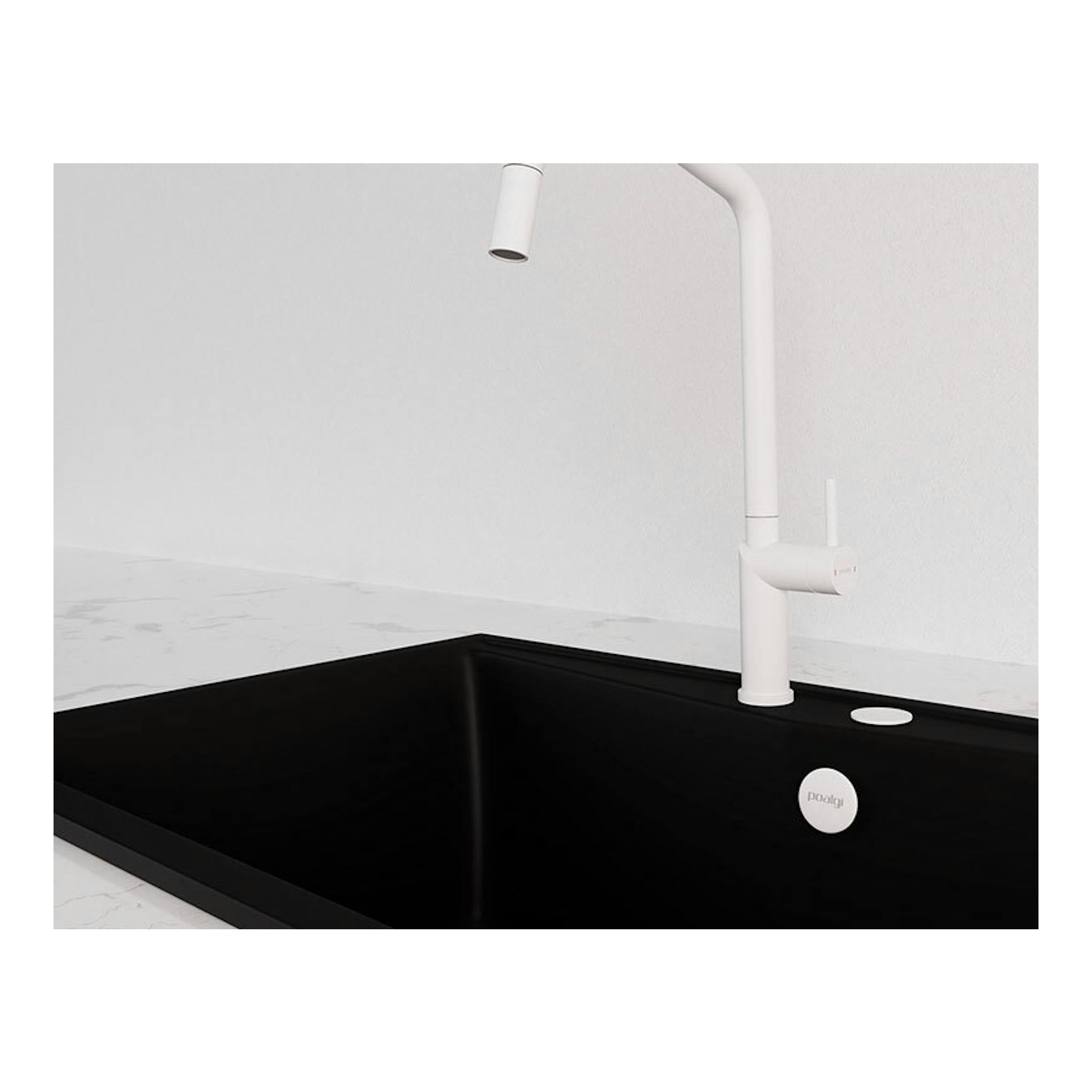 Grifo Poalgi C1BL blanco, vista lateral, sobre fregadero negro de líneas rectas.