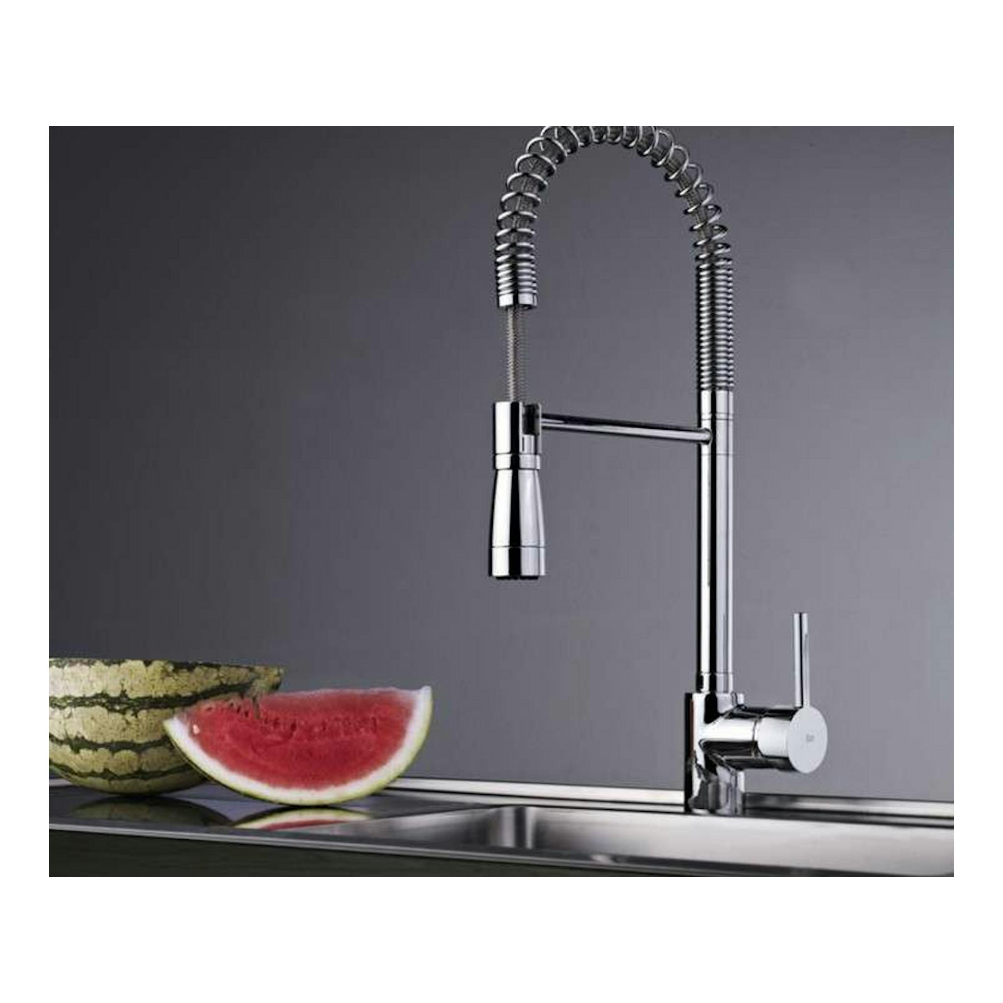 Grifo Teka ARK939 cromado, vista lateral de cocina con caño flexible en arco y palanca, sobre fregadero.