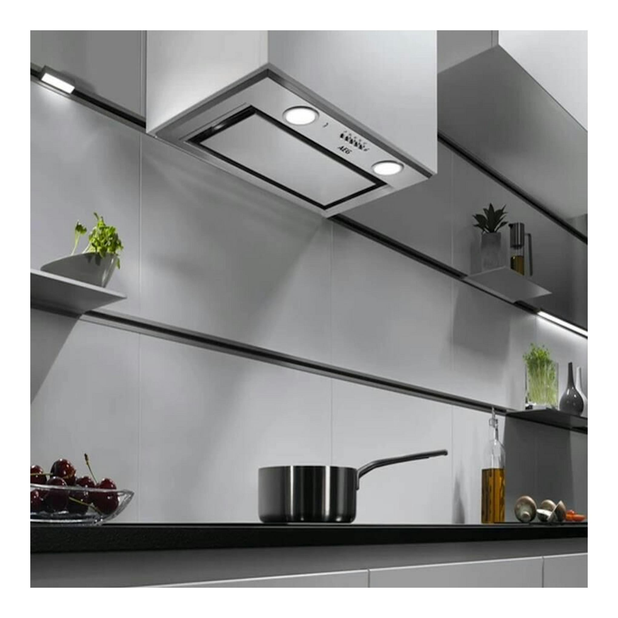Grupo filtrante AEG DGE5661HM inox, vista inferior bajo armario, con dos luces en cocina moderna.