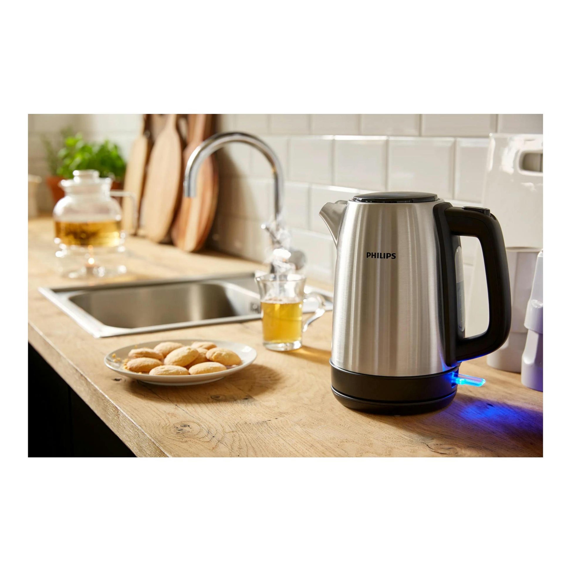 Hervidor Philips HD9350/90 de acero inoxidable, vista lateral en encimera de cocina, con luz azul.