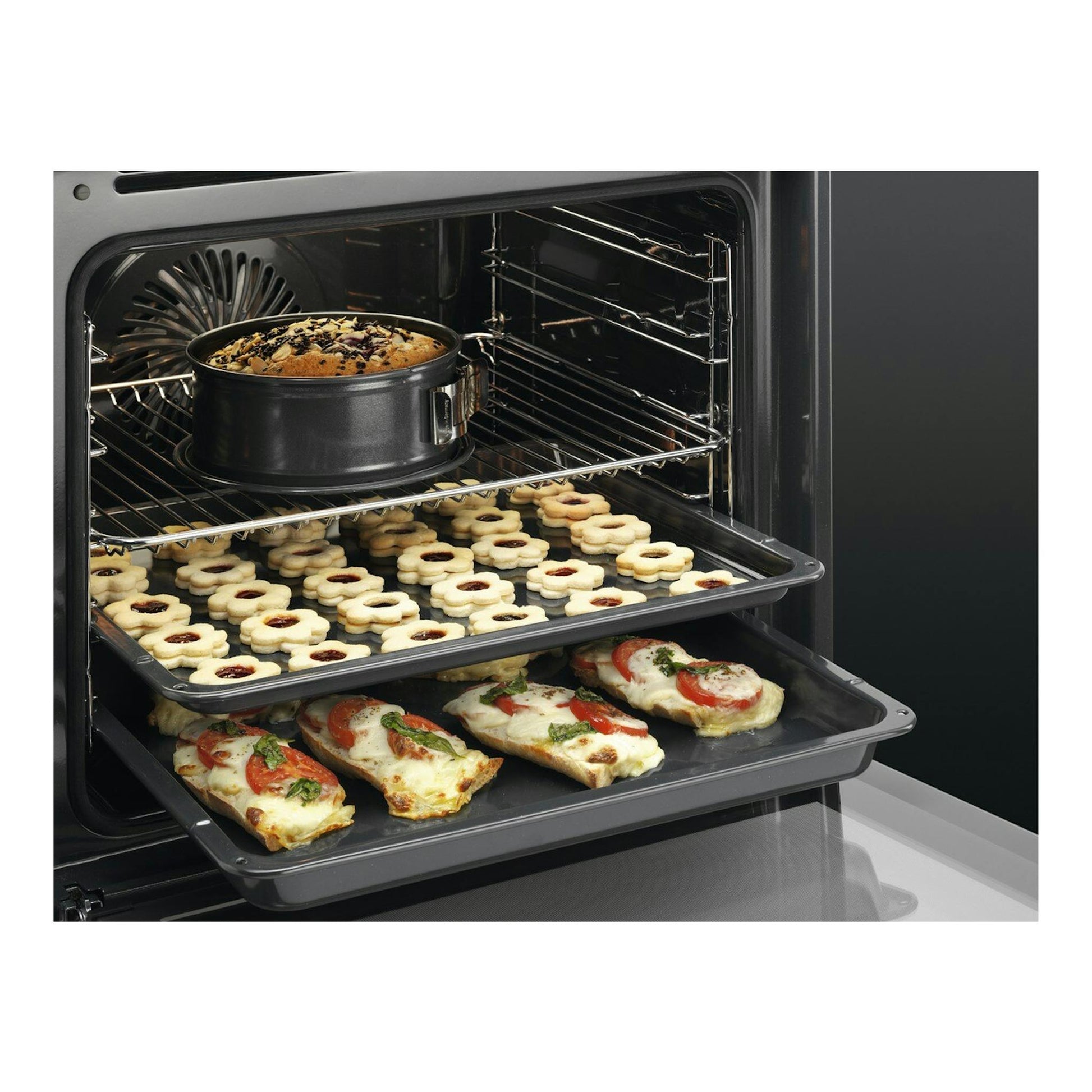 AEG BPB331061M: interior de horno negro con varias bandejas, un pastel, galletas y tostadas.
