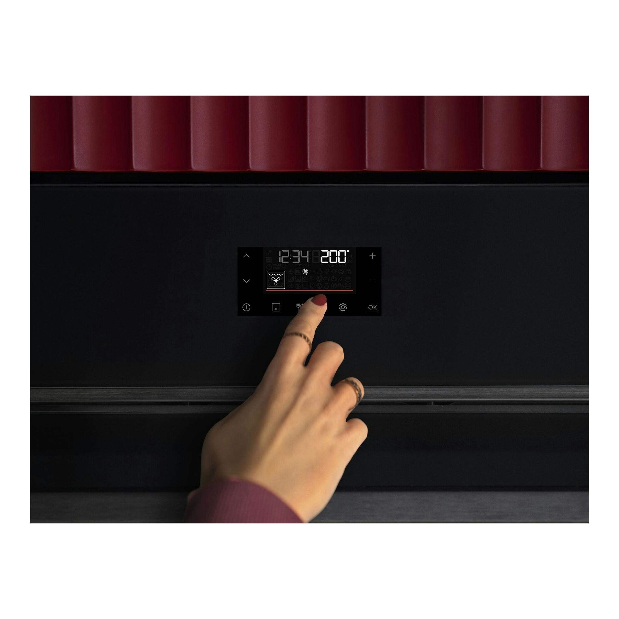 Horno AEG OU5PB43PM negro, vista frontal, con panel táctil digital y una mano tocando la pantalla.
