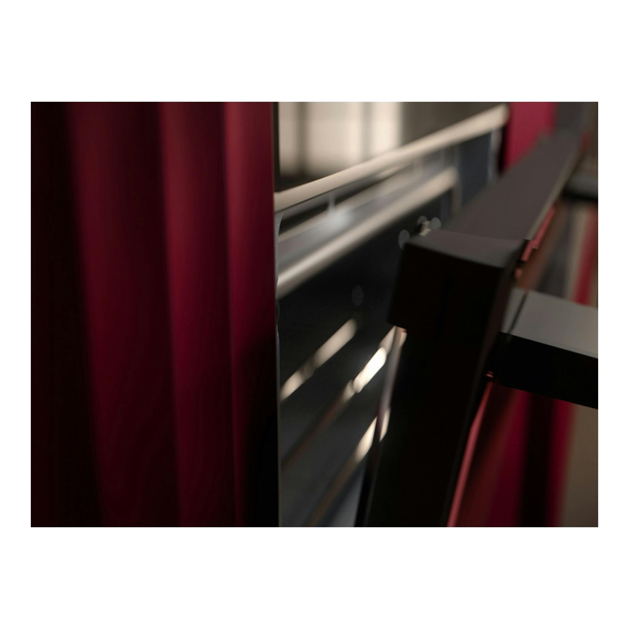 Horno AEG GU5PB43FPM, vista parcial en primer plano de frontal negro con detalles metálicos y reflejos rojos.