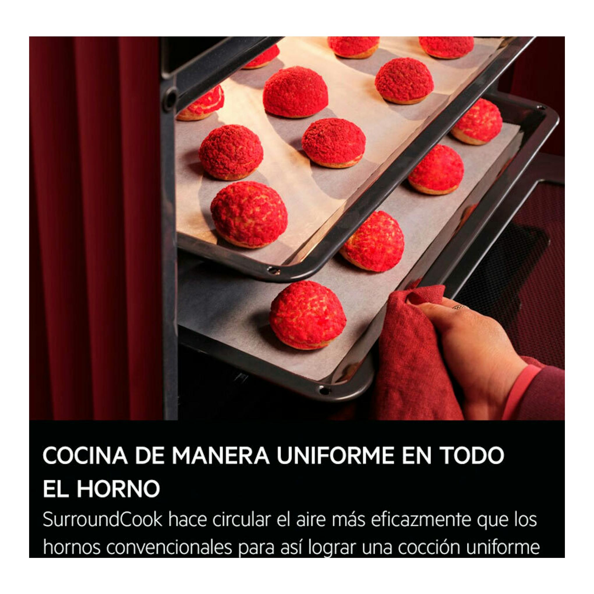 Horno AEG TB8SB73ZAB en negro, con bandejas de repostería y una mano abriendo la puerta.